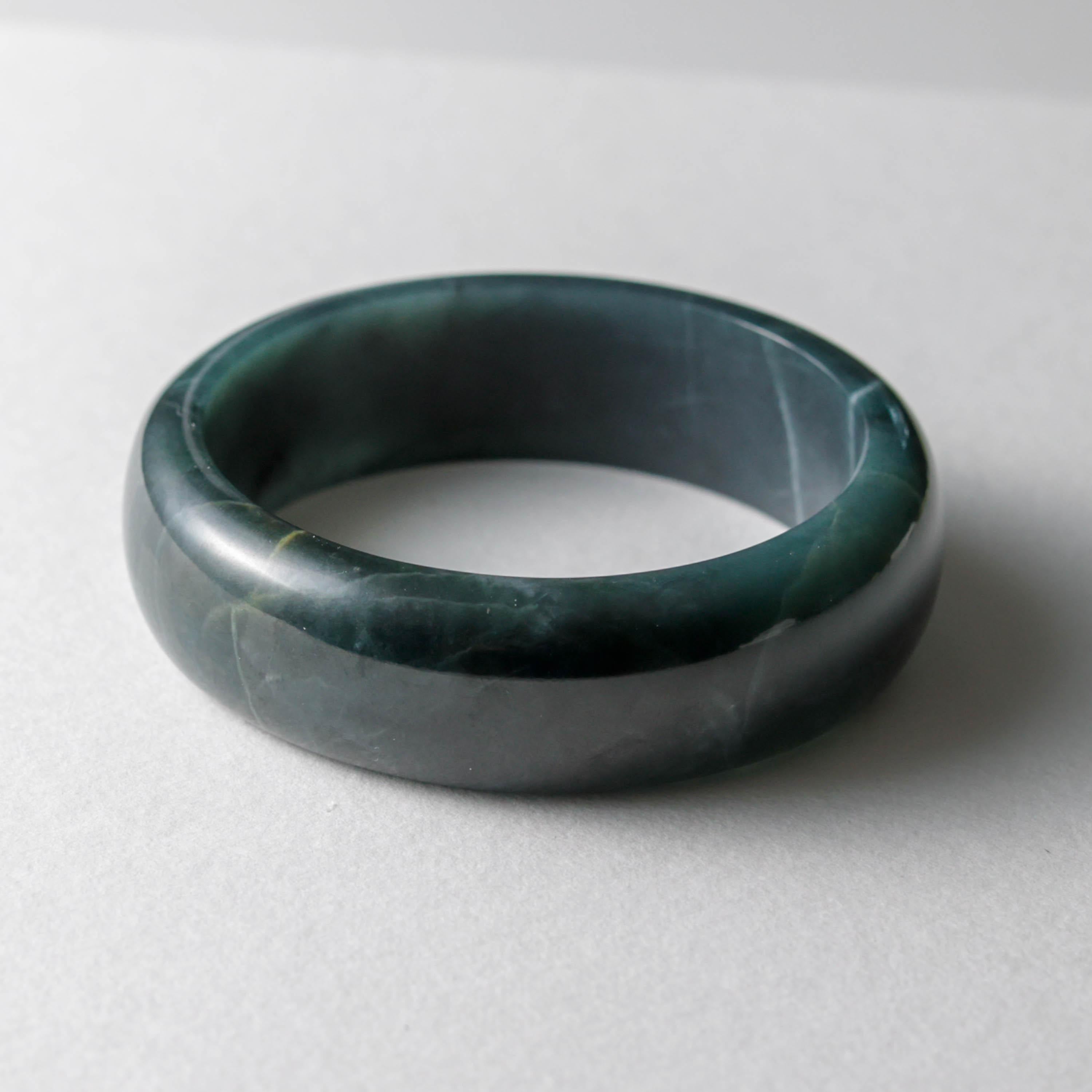 This is a large hand-carved jadeite bangle in extremely rare Guatemala blue jadeite jade. The bangle has an outer diameter of 89mm and an opening of 70mm, meaning it will fit a man with fairly large hands. It's 23.78mm wide and about 10mm thick.