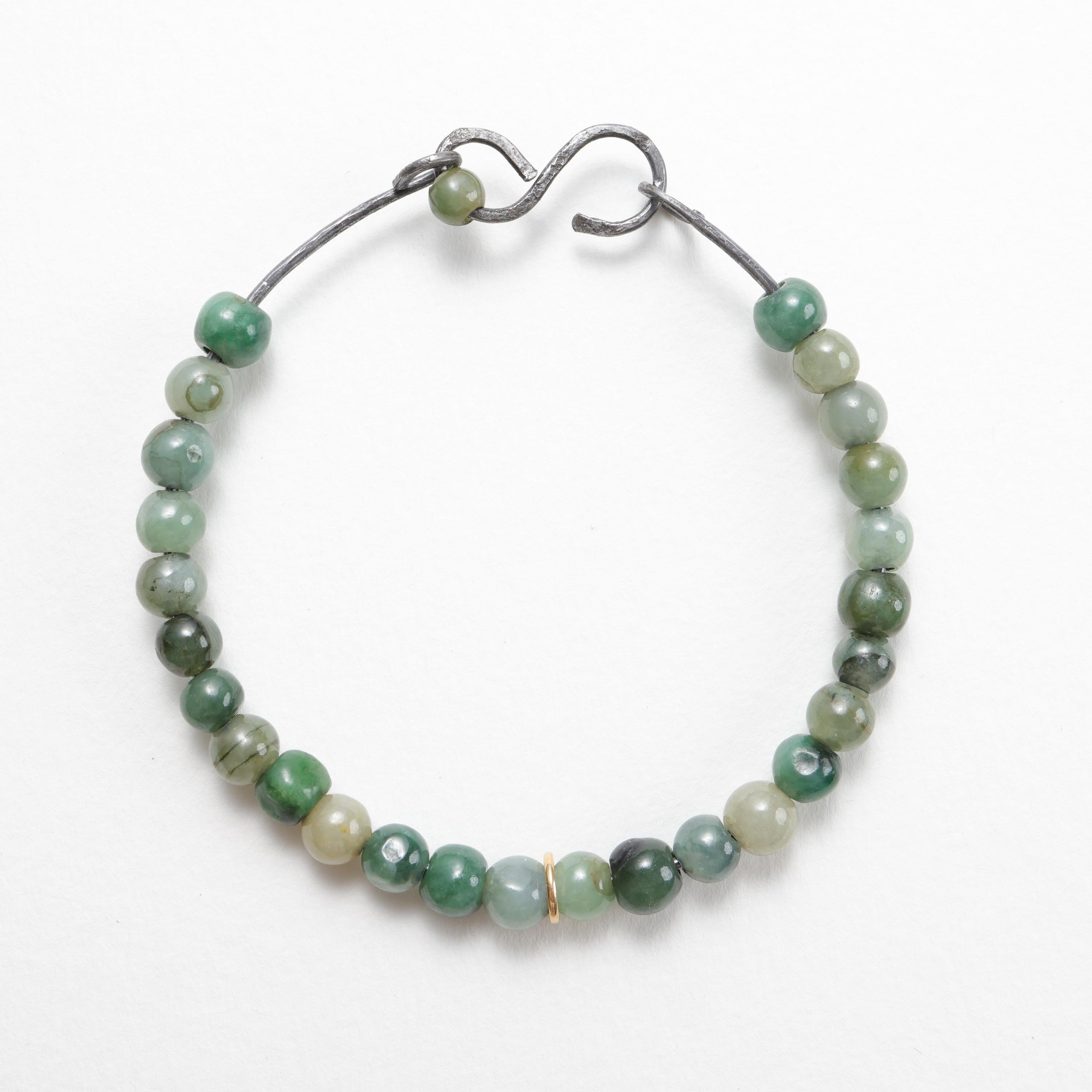 I created this jadeite jade bead bangle with heavy gauge Ohio steel that I hand-worked into shape. This open bangle is worn by sliding your wrist through the bangle's narrow opening. Then you slide the 