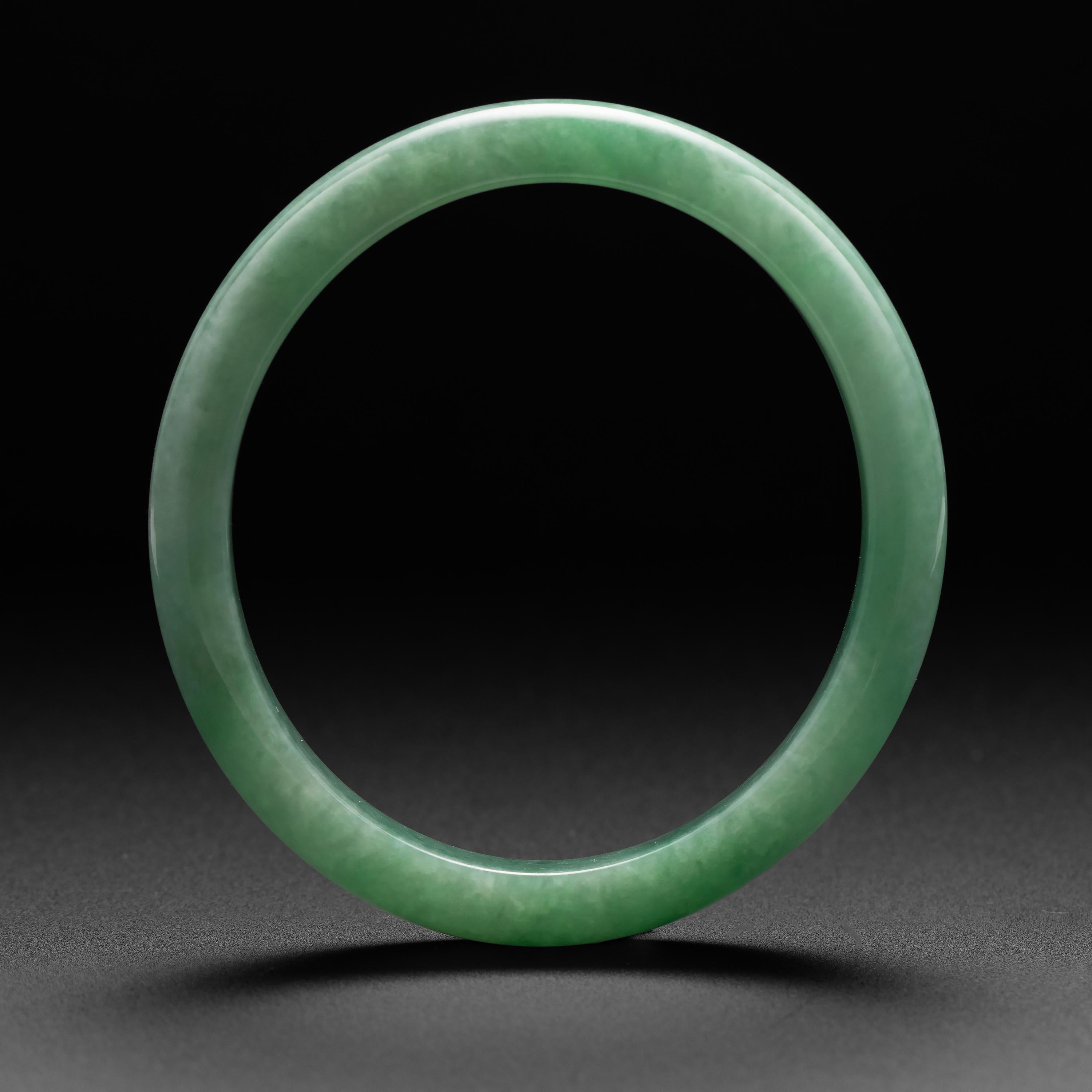 Rare and beautiful, this fresh and light apple green jadeite jade bangle is certified to be natural and untreated. The bangle has been carved in a slightly oval form making it very comfortable for daily wear. The interior diameter at the widest
