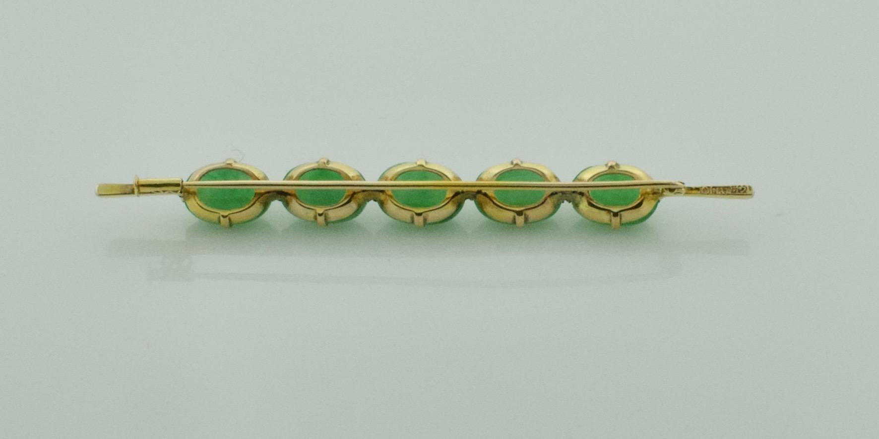 Jade Bar Brooch Circa 1950's in Yellow Gold
Five Matched Oval Cabochon Jadeite Jades 10 x 7 x 3.3 mm 9.00 carats approximately bright with nice translucency  
