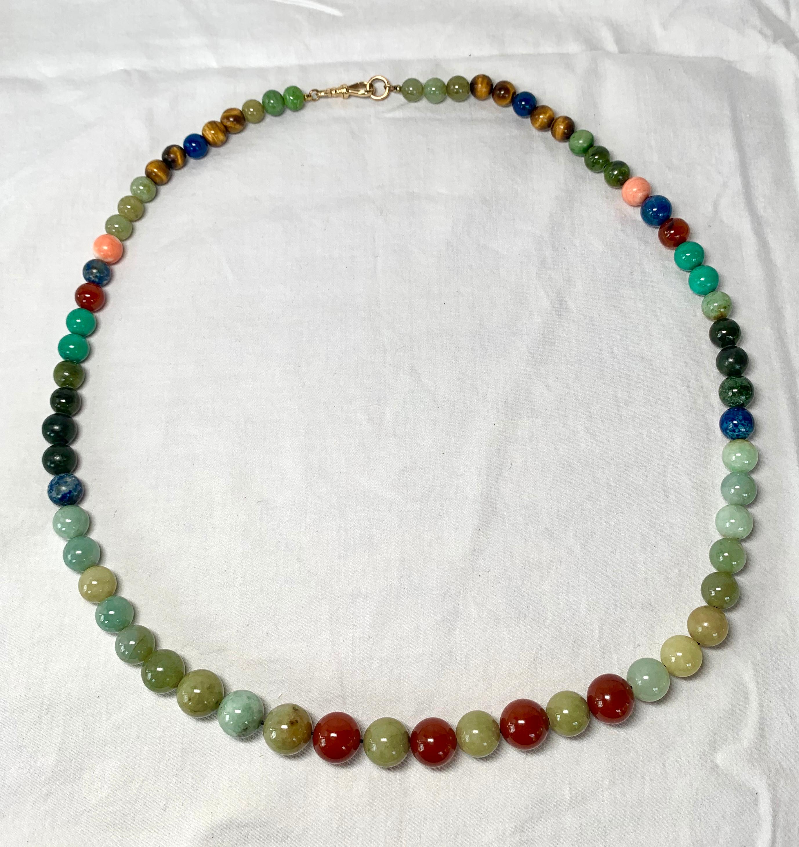 A spectacular natural mined gemstone necklace with graduated beads of Jade, Carnelian, Lapis Lazuli, Malachite, and Tiger's Eye with a rare and wonderful Dog Clip Clasp in 14 Karat Gold.  The necklace is 26 inches (63 cm) long.    The graduated