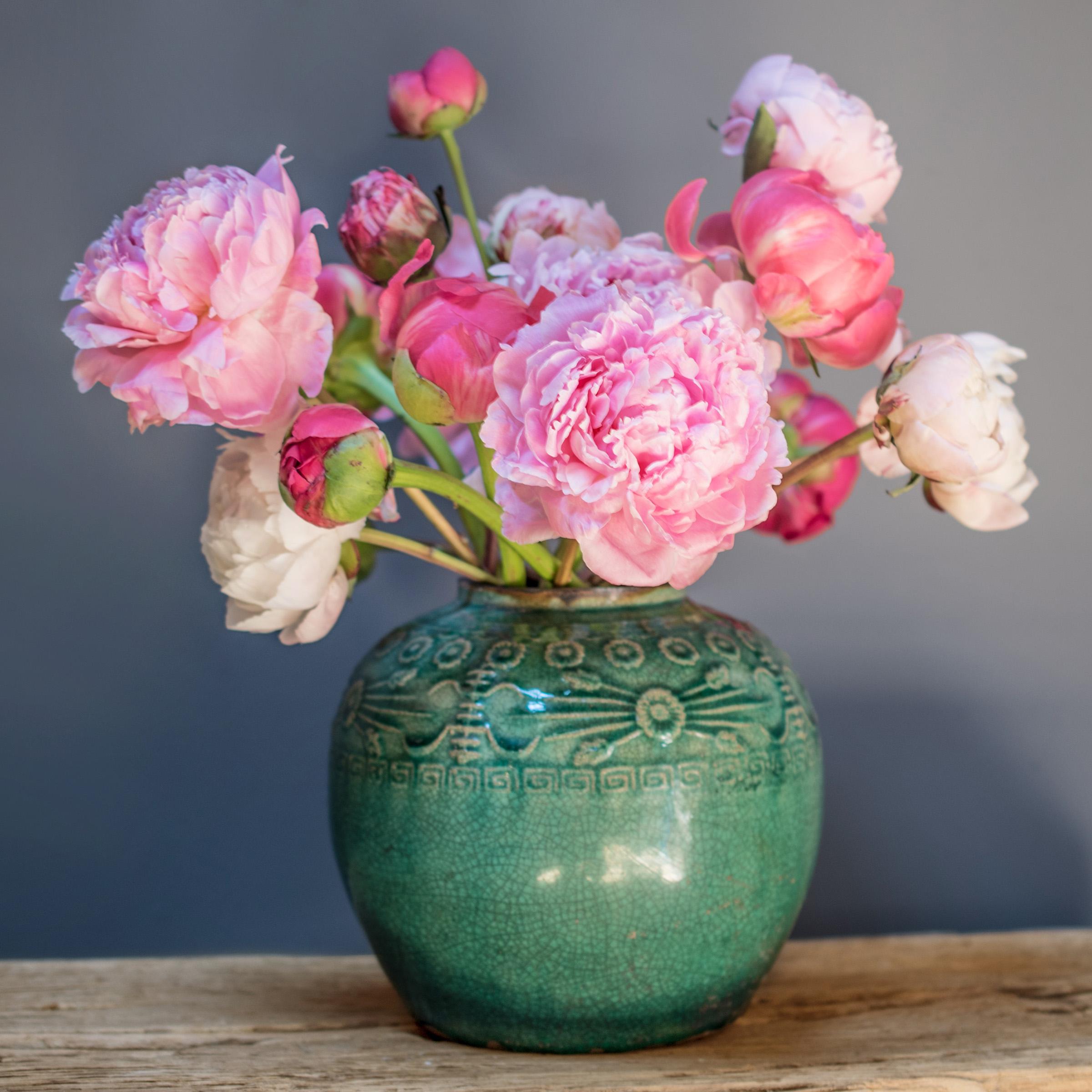 A glassy, blue-green glaze sheets, pools, and drips across the rounded body of this provincial kitchen pot, lingering beautifully on the low relief decoration to the jar's shoulders. Among the raised patterns are round chrysanthemum blossoms and
