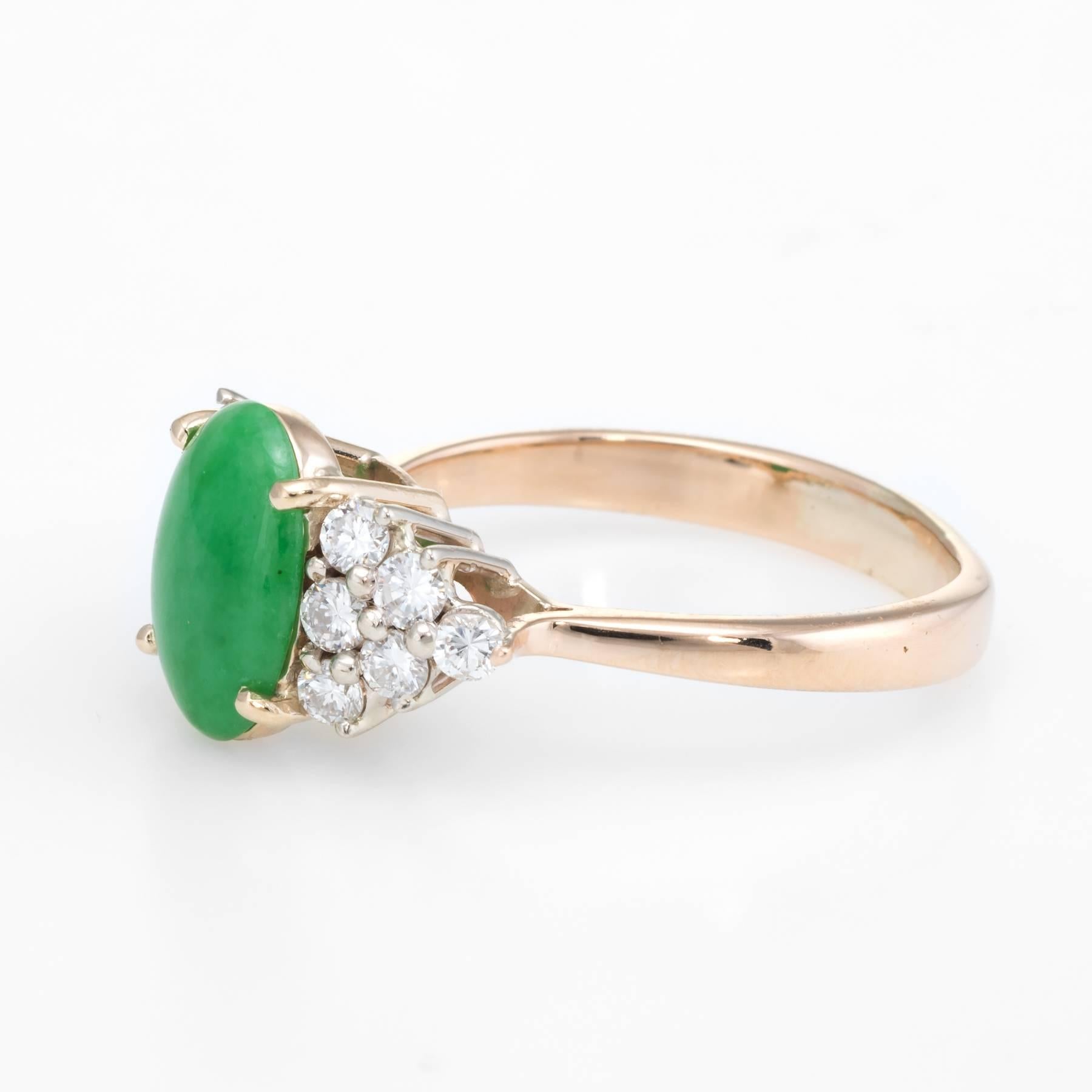 Elegant vintage cocktail ring, crafted in 14 karat yellow gold. 

Centrally mounted cabochon cut jade measures 11mm x 8mm (estimated at 4 carats), accented with 12 x 0.04 carat round brilliant cut diamonds. The total diamond weight is estimated at