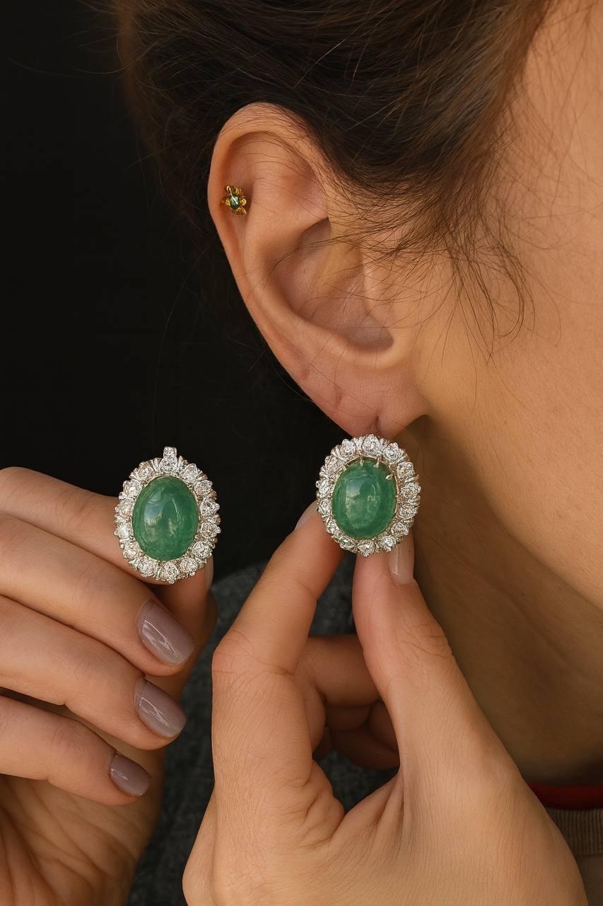 Boucles d'oreilles en jade et diamants, vers 1940
or 18K  Poids total : 16,80 g  Prix : 6 600

Une paire de boucles d'oreilles raffinées des années 1940, avec des centres en jade cabochon vert vif encadrés par un halo de diamants ronds de taille