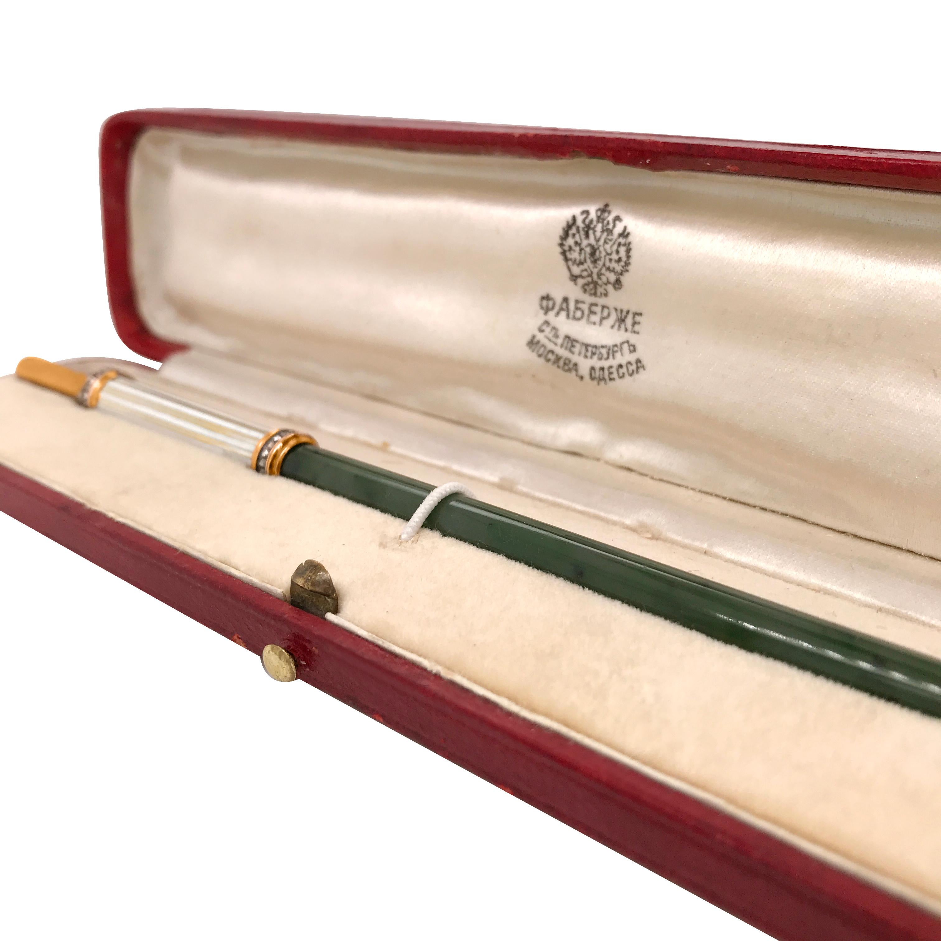 This authentic jade, diamond and enamel Faberge dip pen is rendered in 14K yellow gold, made by Henrik Wigstrom (1862-1923). The handle is adorned with white and golden enameled and the body is crafted in jade. Further enhanced by 42 rose-cut