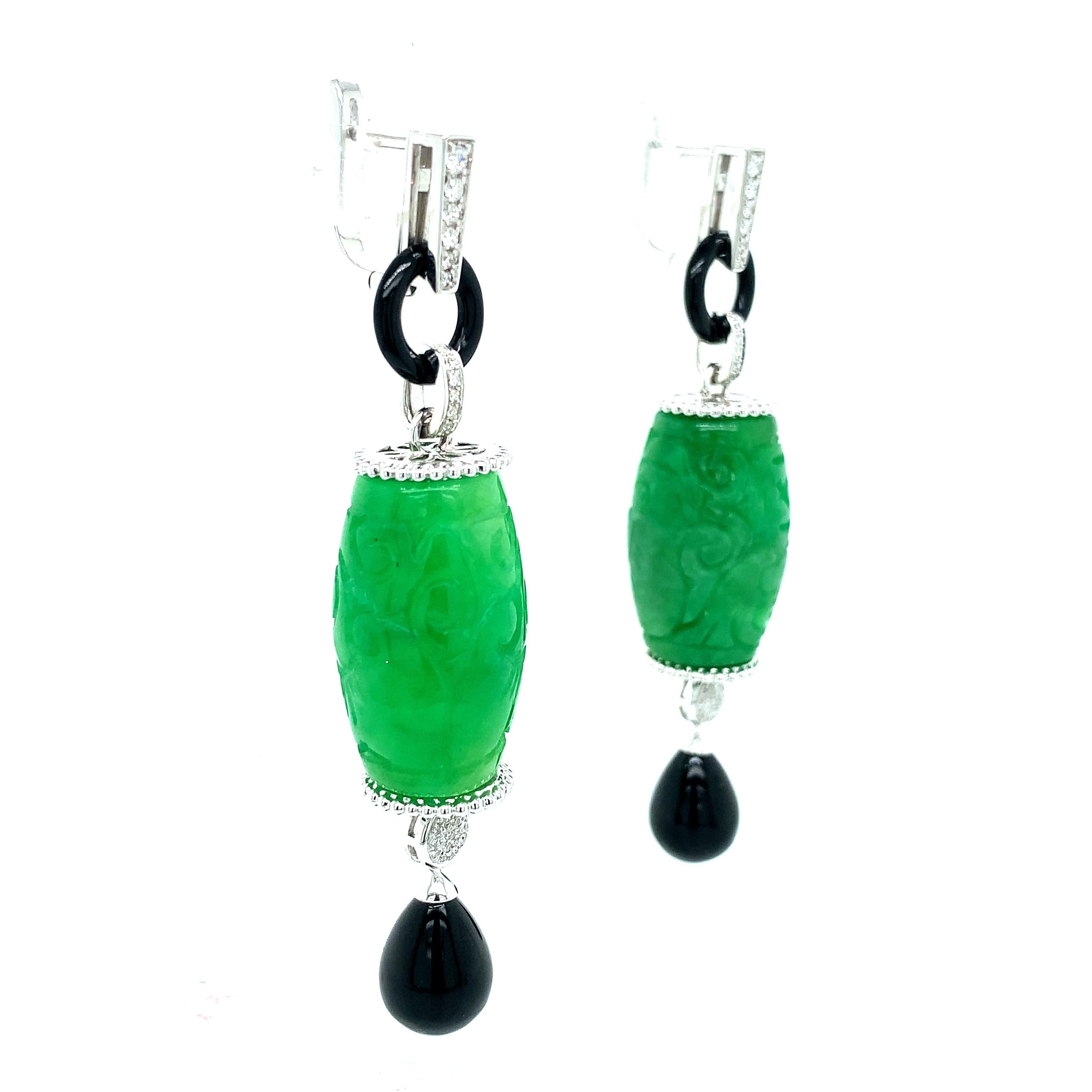 A pair of jade dangling earrings that also consists of single-cut diamonds and black onyx. Total weight: 27.4 grams. Width: 1.5 cm. Length: 6.6 cm. 