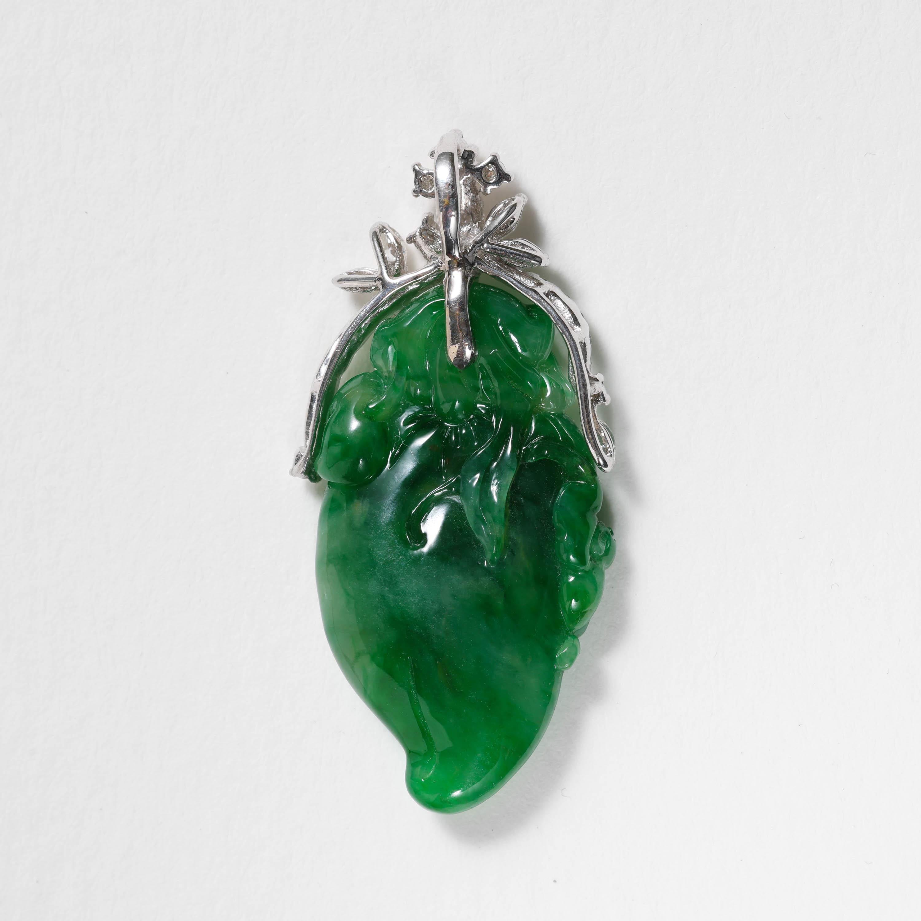 Rich, emerald-green certified natural and untreated Burmese jadeite jade has been whimsically and masterfully carved into a chili pepper with leaves. An adorable, tiny bat clings to the side of the pepper. The symbolism here is prosperity and good