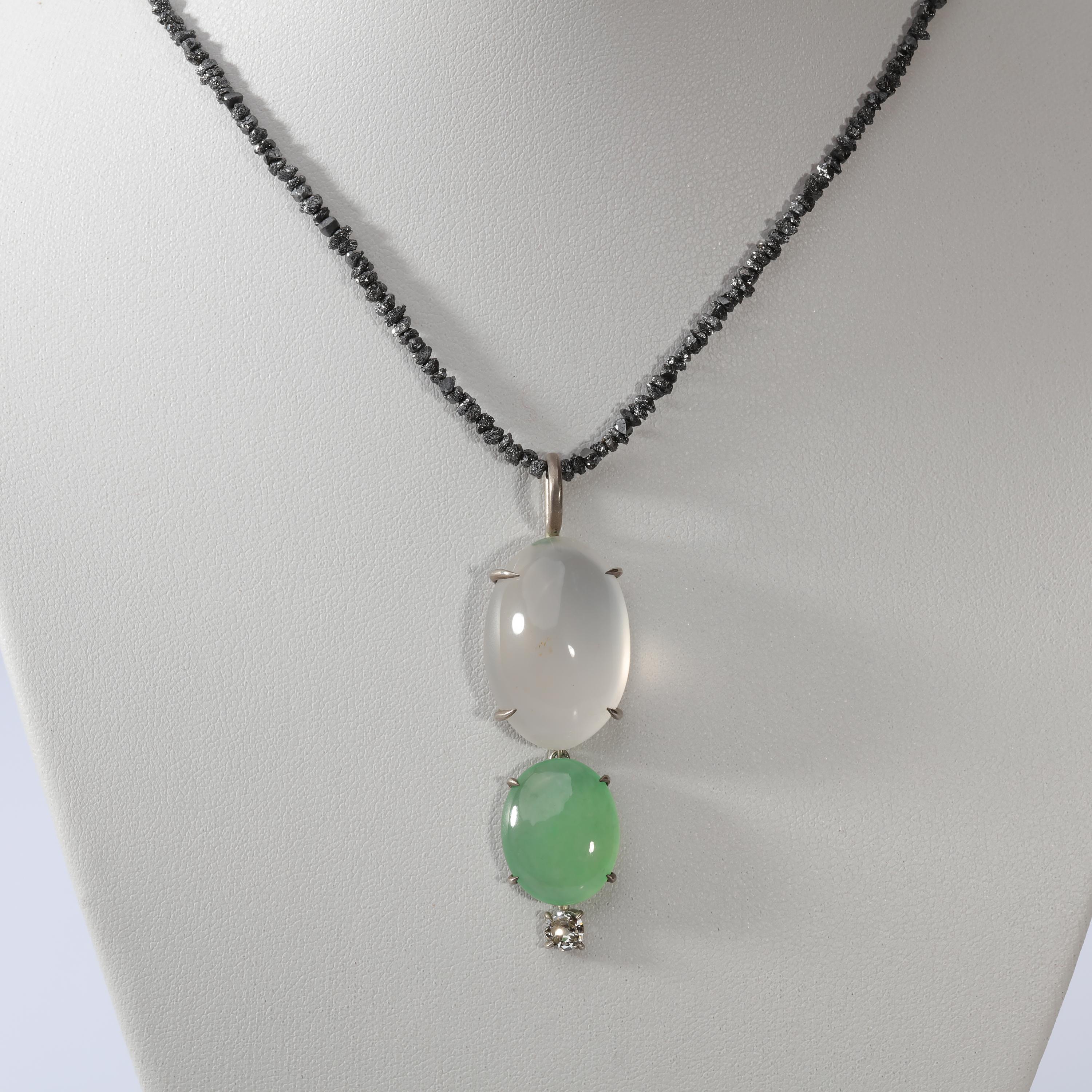 This jade, diamond, and quartz pendant is a study in translucency. The 25.5mm x 17.5mm oval natural quartz cabochon at the top is semi-transparent and glows like partially melted ice. Hanging freely from the mounting that holds the quartz is a