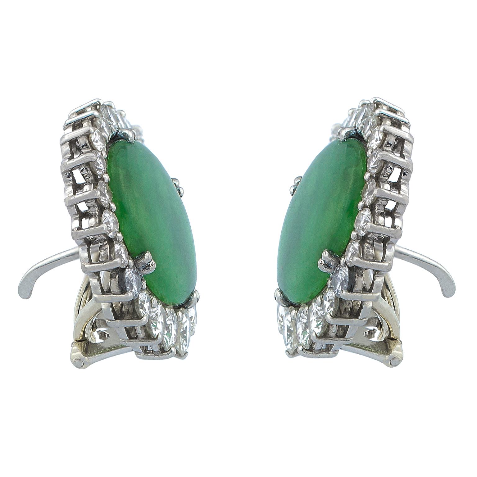 White gold earrings centered by oval jades surrounded by 38 round brilliant diamonds in increasing size set on three-prong mounts, totalling 2.74 carats in weight.