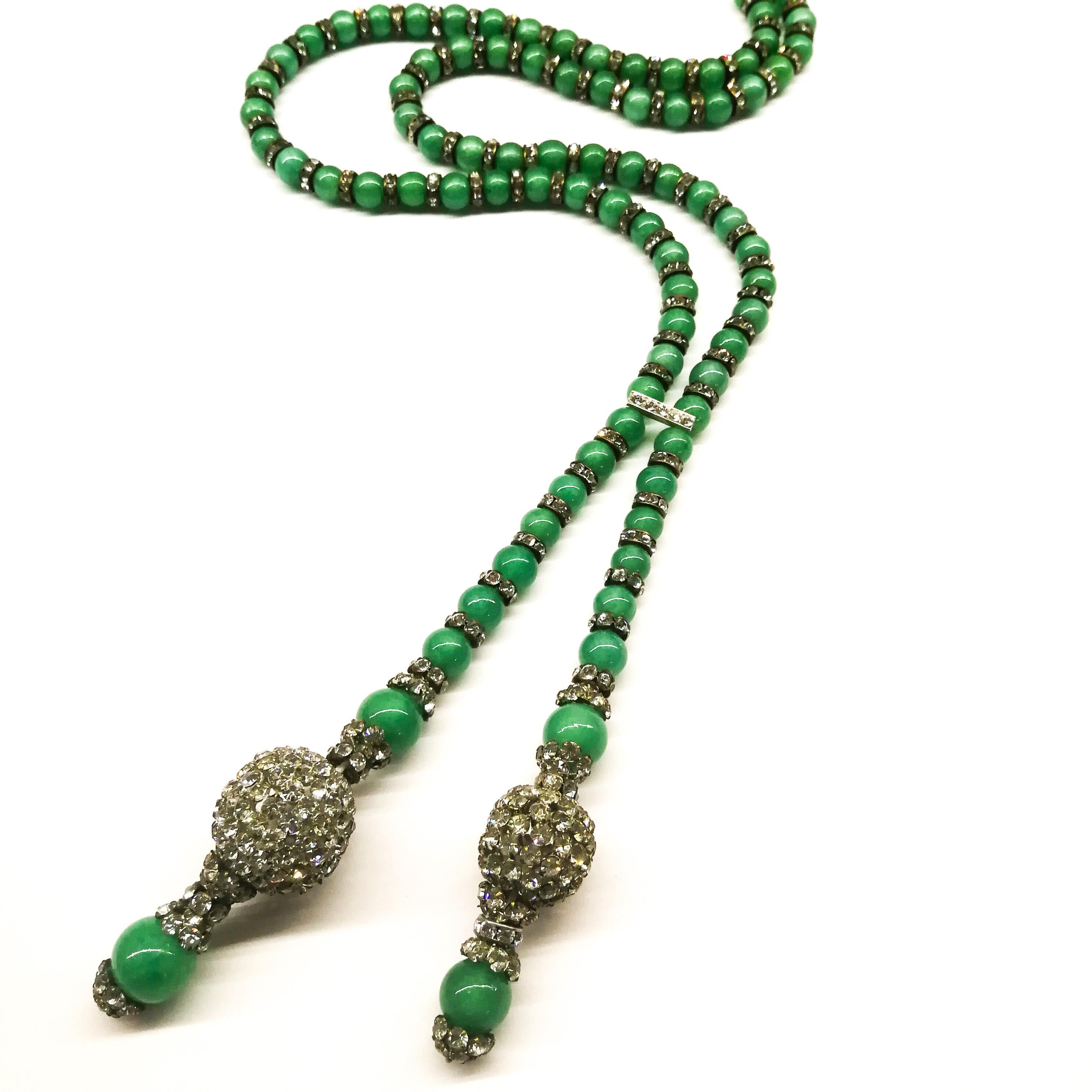 An elegant and eye catching long sautoir, in a soft 'jade' green, from France, in the 1920s. Made from imitation jade glass round beads, and clear paste rondelles, caps and balls, it is gently 'drawn together' by a paste bar, allowing the two drops