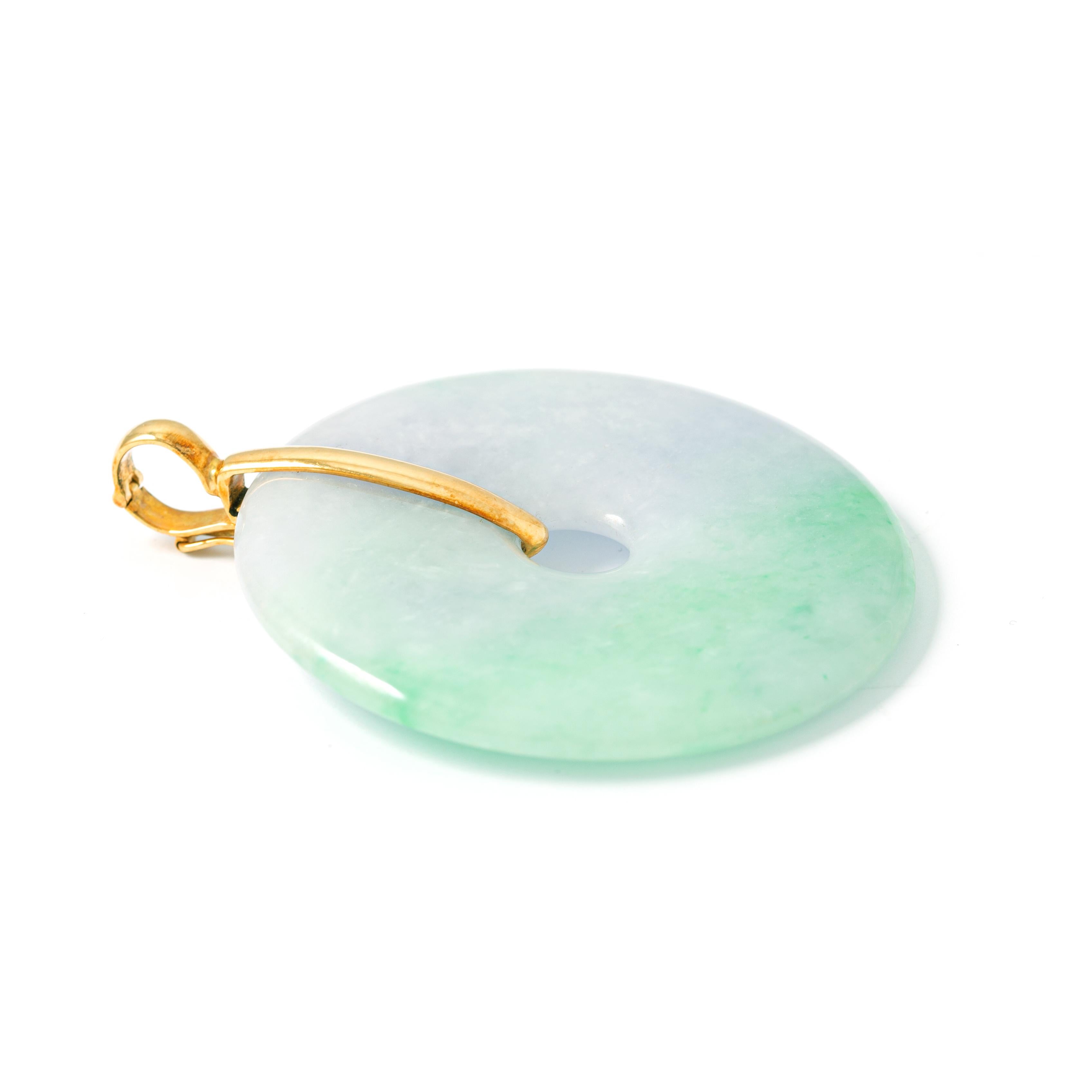18K yellow gold pendant holding a jade. 
Length: 6.70 cm. 
Gross weight: 43.40 grams.
