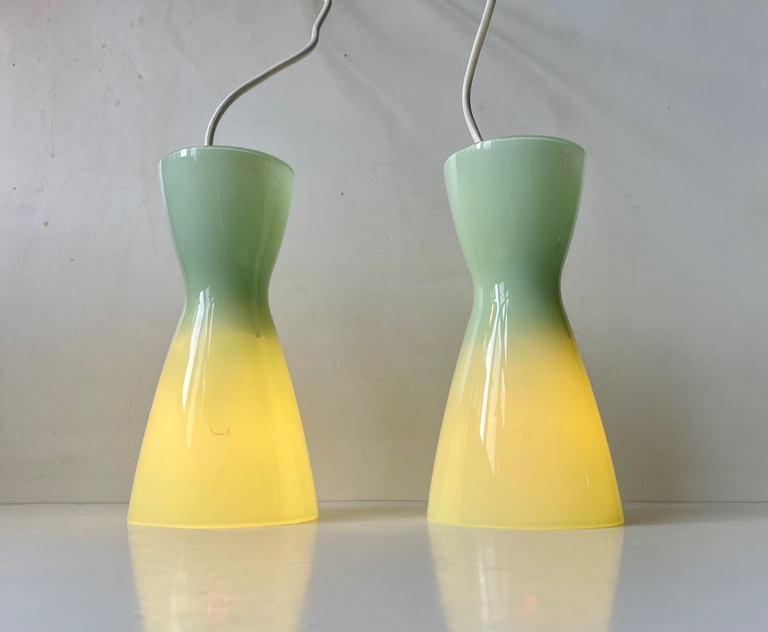 A pair of Jade green hand blown opaline glass pendant lights designed by Peter Svarrer and manufactured by Holmegaard in Denmark during 1990s. Suitable as kitchen lighting, entrance, hallway, corner lighting etc. Both with original sticker attached