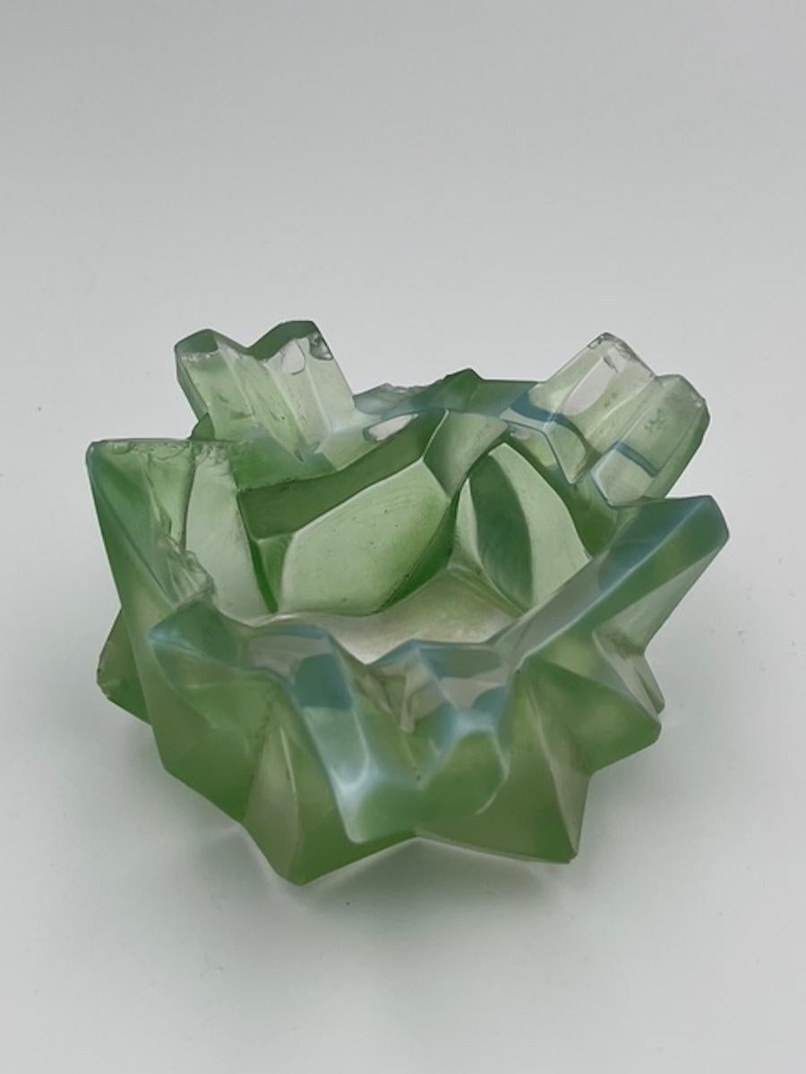 The Ruba Rombic ashtray, produced by the Consolidated Glass Company, stands as an iconic example of Art Deco design. Crafted in Jade green cased glass, this stunning piece features bold geometric shapes and symmetrical patterns, epitomizing the