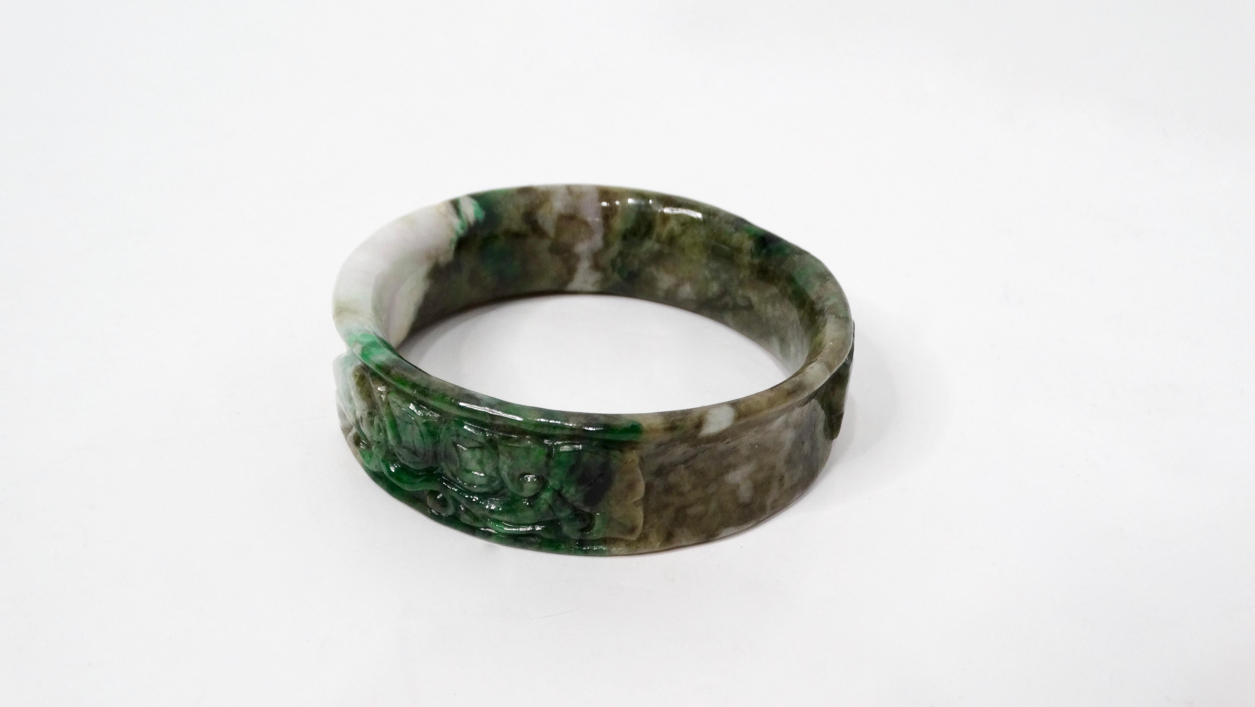 The Vintage Hand-Carved Gradient Jadeite Bangle is a stunning piece that embodies elegance and craftsmanship. Crafted from jadeite, this bangle features a beautiful gradient hue that transitions seamlessly from deep emerald to soft pastel green,