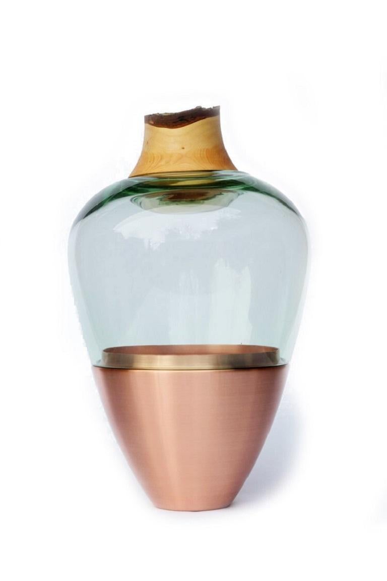 Jade India Vessel I, Pia Wüstenberg.
Dimensions: D 20 x H 38.
Materials: glass, wood, metal.
Available in other metals: brass, copper.

Handmade in Europe, by individual craftsmen: handblown glass (Czech Republic), hand spun metal, (England),