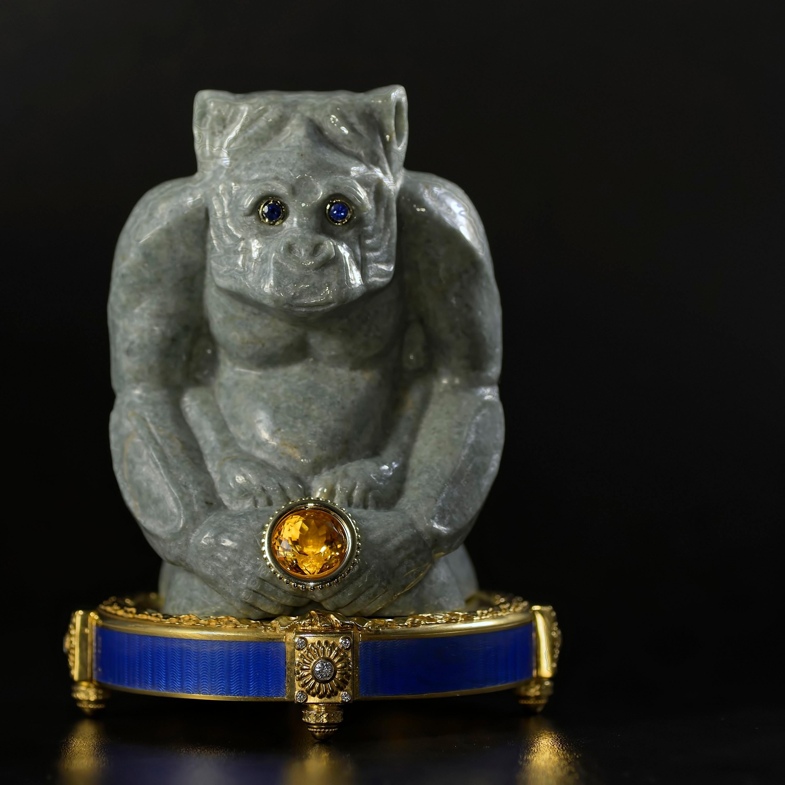 Jade monkey sculpture in Burmese jadeite, eyes set with gold and sapphires, paws holding a gold encased citrine. Pedestal in 24K plated sterling silver, set with diamonds, and covered with blue guilloche enamel.

A wise ape looks on with wonder and