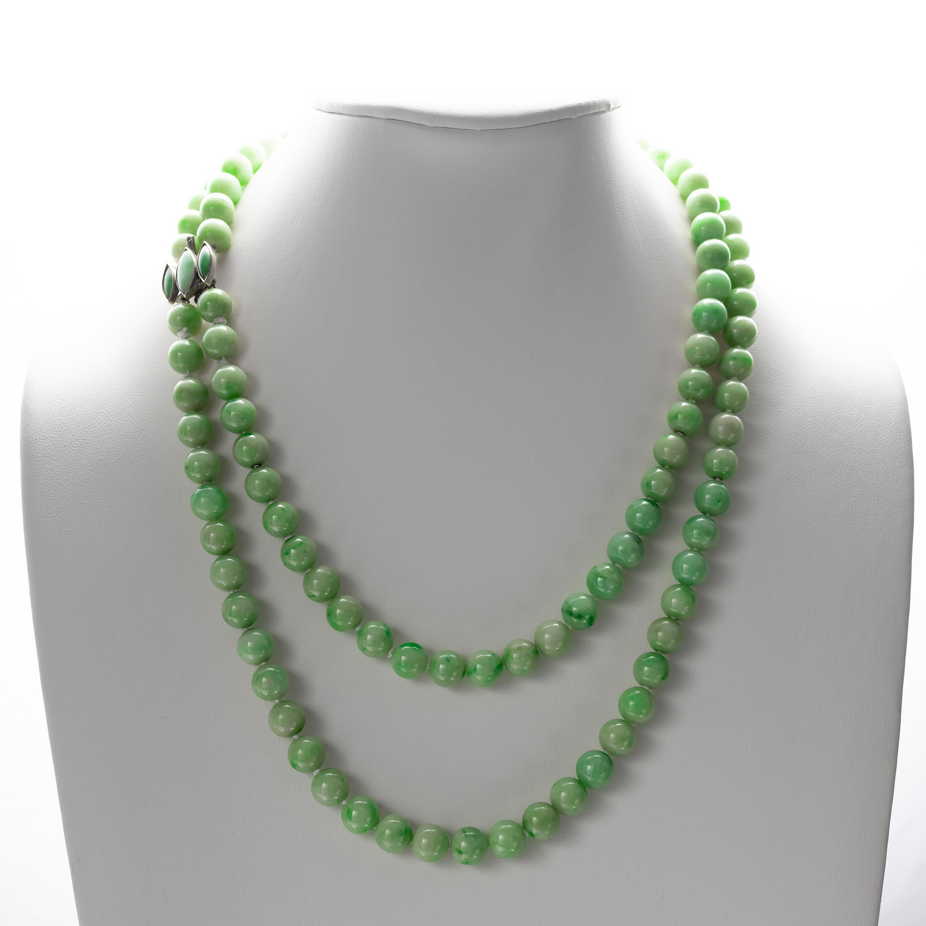 Grand, beautiful, and rare, this doubler-strand jade necklace features 114 hand-carved and polished untreated Burmese jadeite beads. The fresh and light apple green jadeite beads are nearly uniform in size, measuring approximately 9.5mm. These are