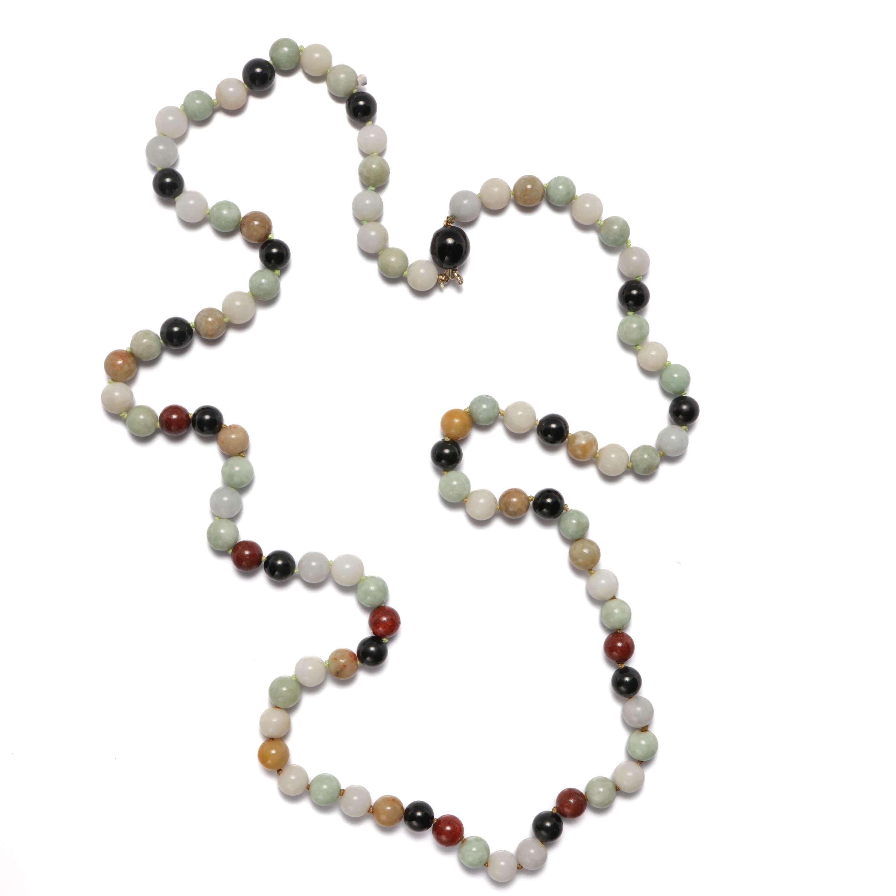 This sophisticated jade necklace features 76 9mm hand-carved round Burmese jadeite jade beads in a range of muted tones (the black beads are not jade). 

The 35