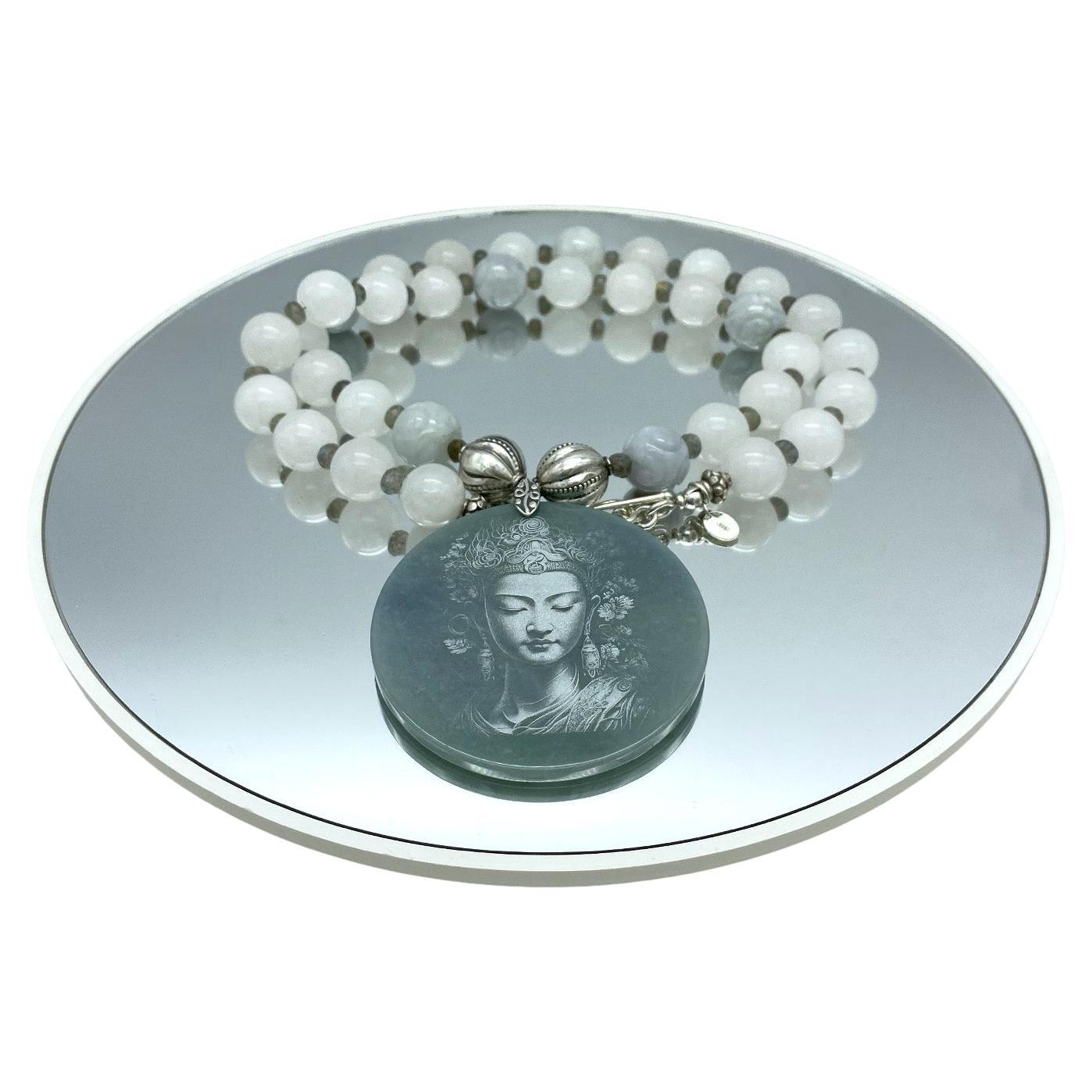 This is a grade A jadeite necklace with a Guanyin pendant. We created this long strand necklace with 12 mm smooth white jade beads with six carved lite green jade beads and a shadow carving Guanyin Bodhisattva pendant. Faceted Labradorite as spacers