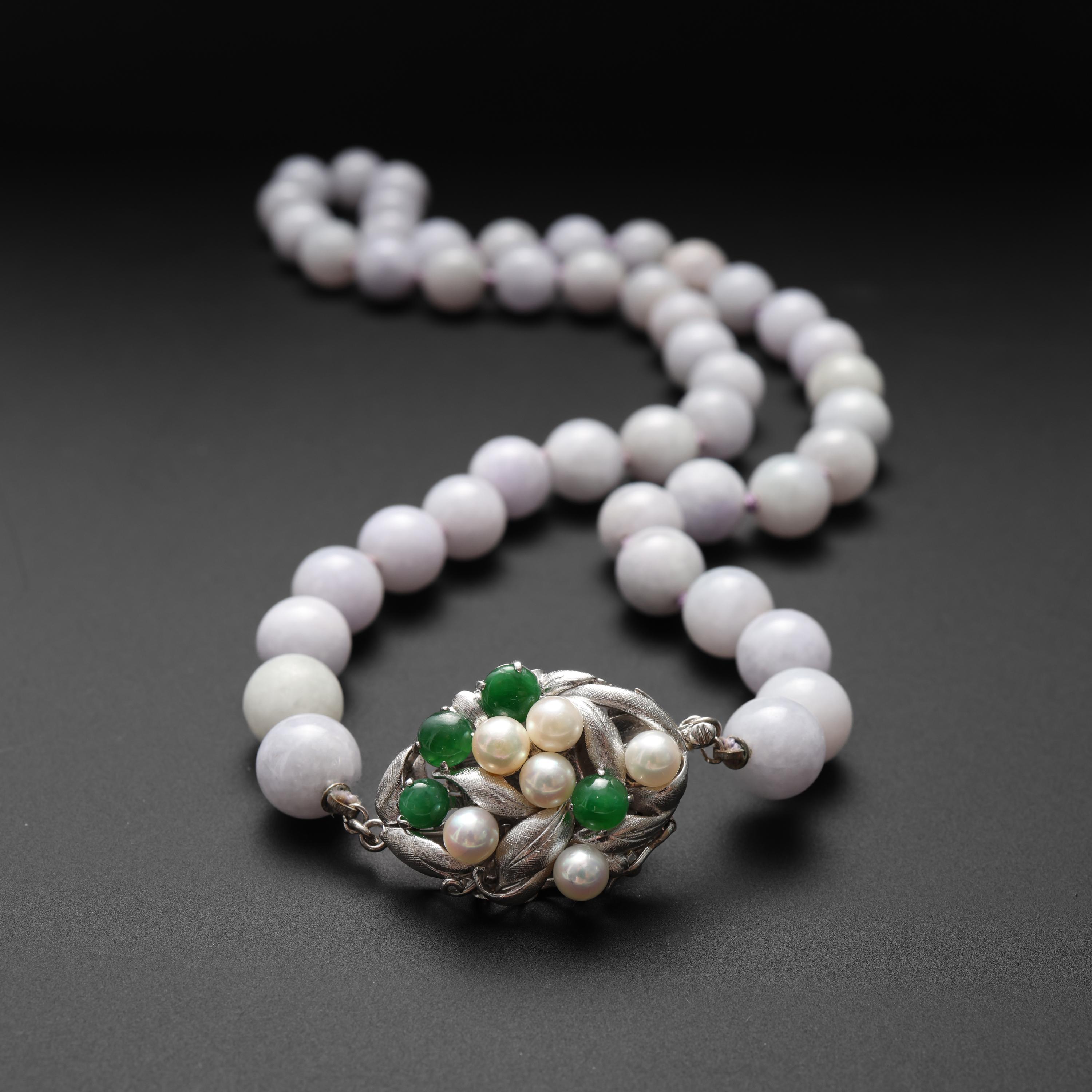 This gorgeous certified natural and untreated Burmese jadeite jade necklace is composed of 45 10mm hand-carved and polished light lavender jade beads. As with most lavender jade, the stones are opaque yet somehow still luminous. The gem lab