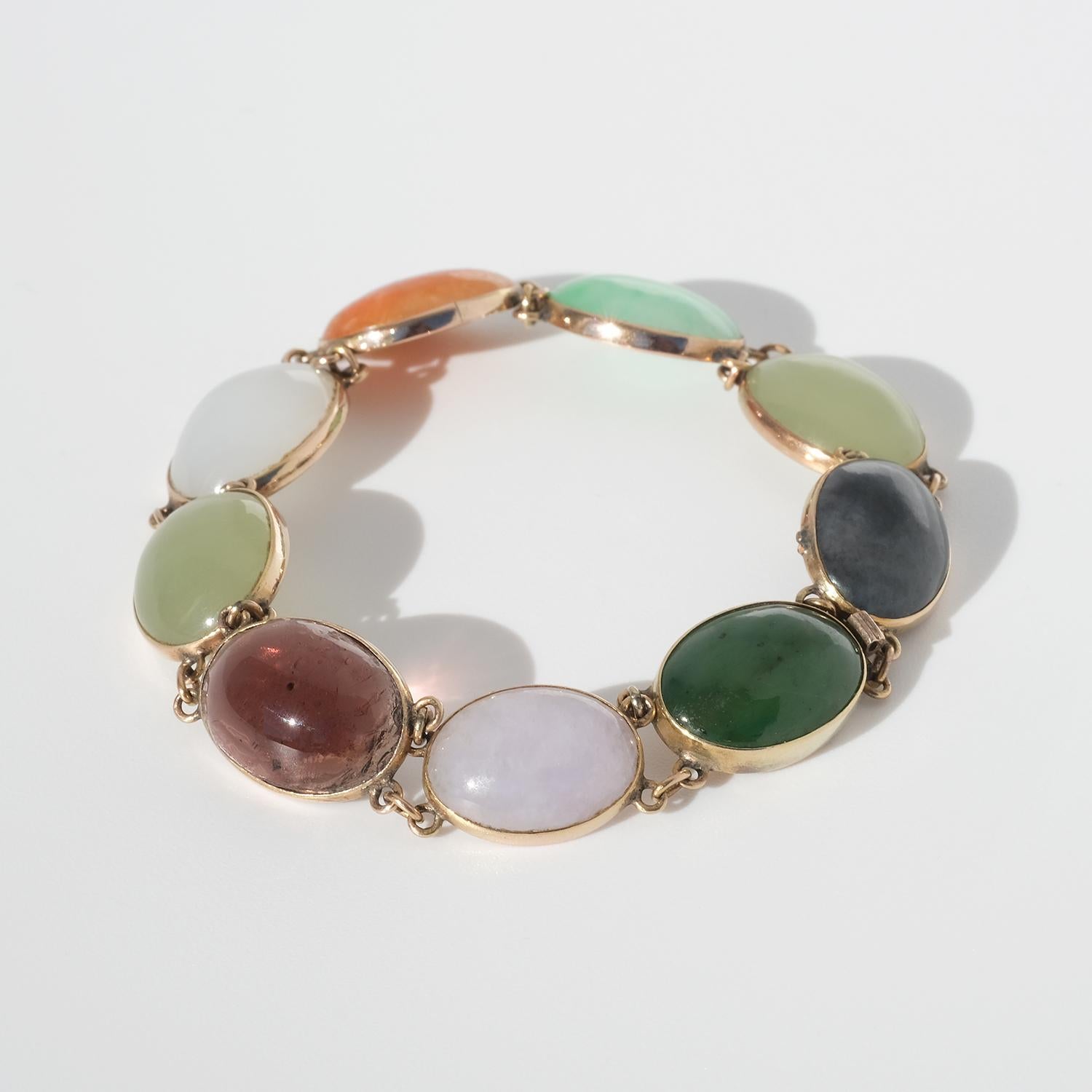Dieses Armband aus 14 Karat Gold ist mit Jade-, Nephrit- und Quarzsteinen im Cabochon-Schliff geschmückt. Das Armband wird mit einer Schließe aus Schachtel geschlossen.

Das Armband fällt wie ein Schmetterling an das Handgelenk und verleiht mit