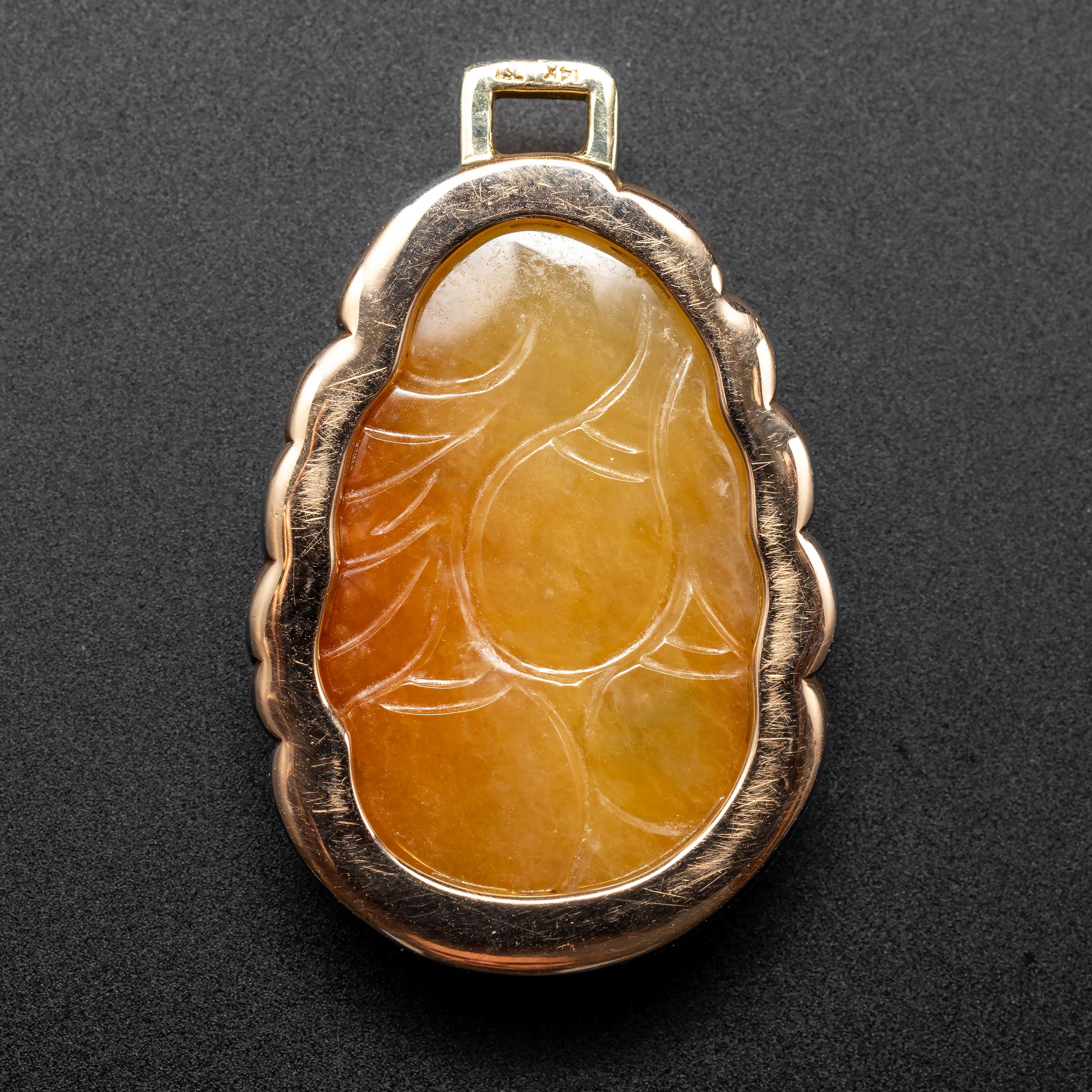 This succulent reddish-orange jade pendant was hand-carved in the middle of the previous century (circa 1970s) and depicts peaches, long a symbol of longevity. The rear of the pendant is deeply carved. A handmade 14K rose gold frame holds the jade