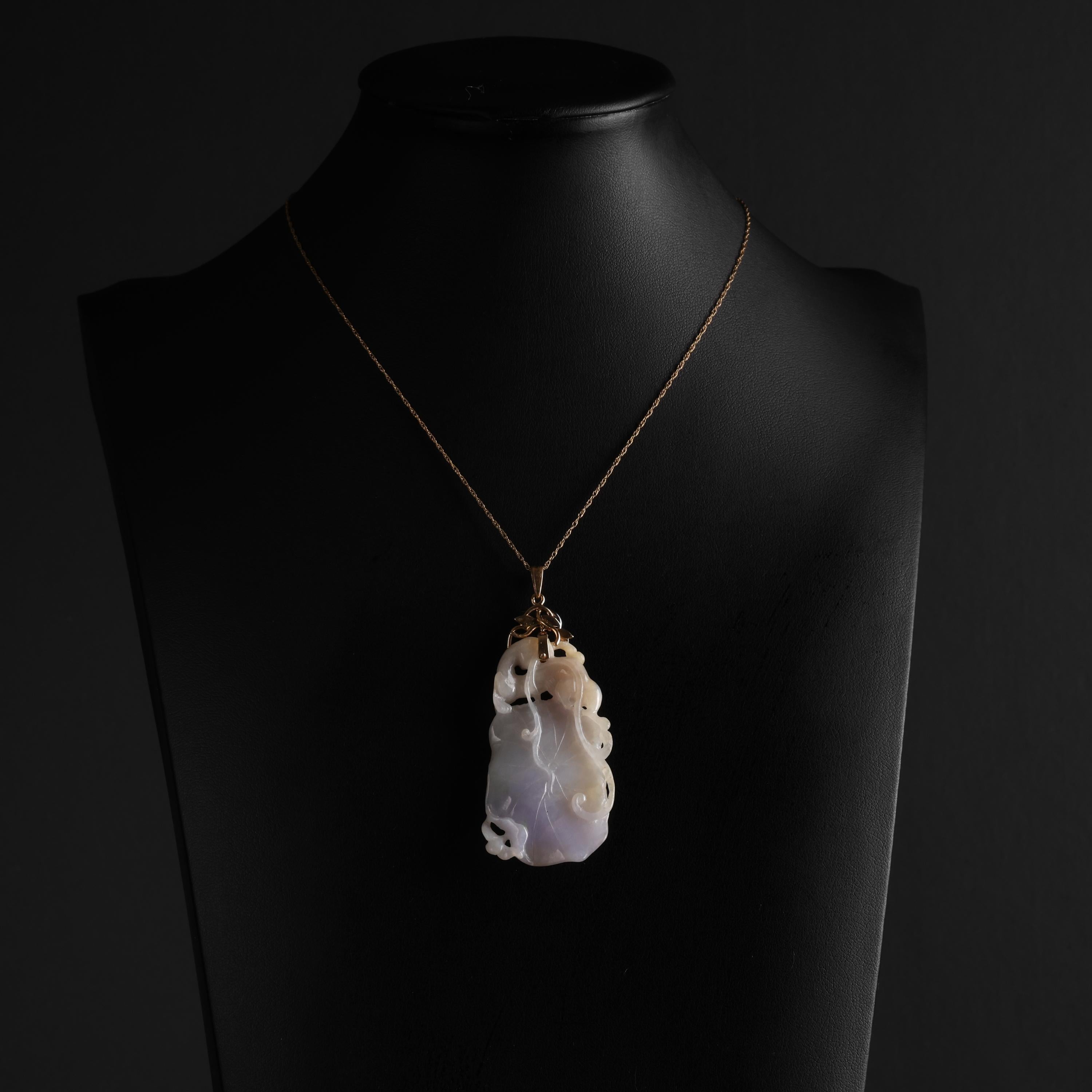 The true beauty of this carved jadeite jade pendant is difficult to capture in photographs; more difficult still to describe in words. Carved by hand in the form of an entangled squash blossom, the jade stone is highly translucent; the light