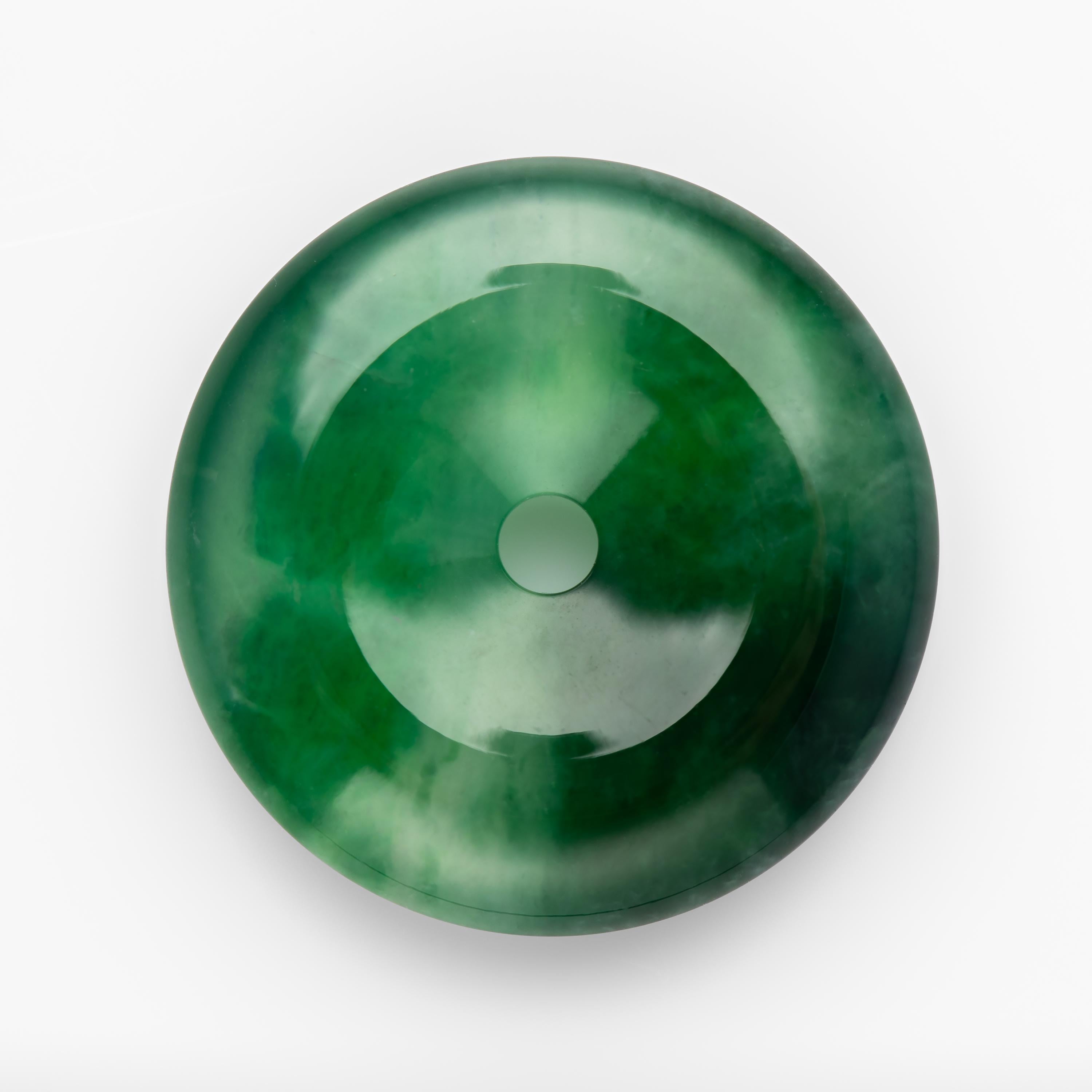 The glassy emerald-green jadeite jade disk you see here is the finest one I have encountered in a very long time. The rich coloring combined with the glassy, watery translucency, and the impossibly delicate mottling that reveals the fine grain of