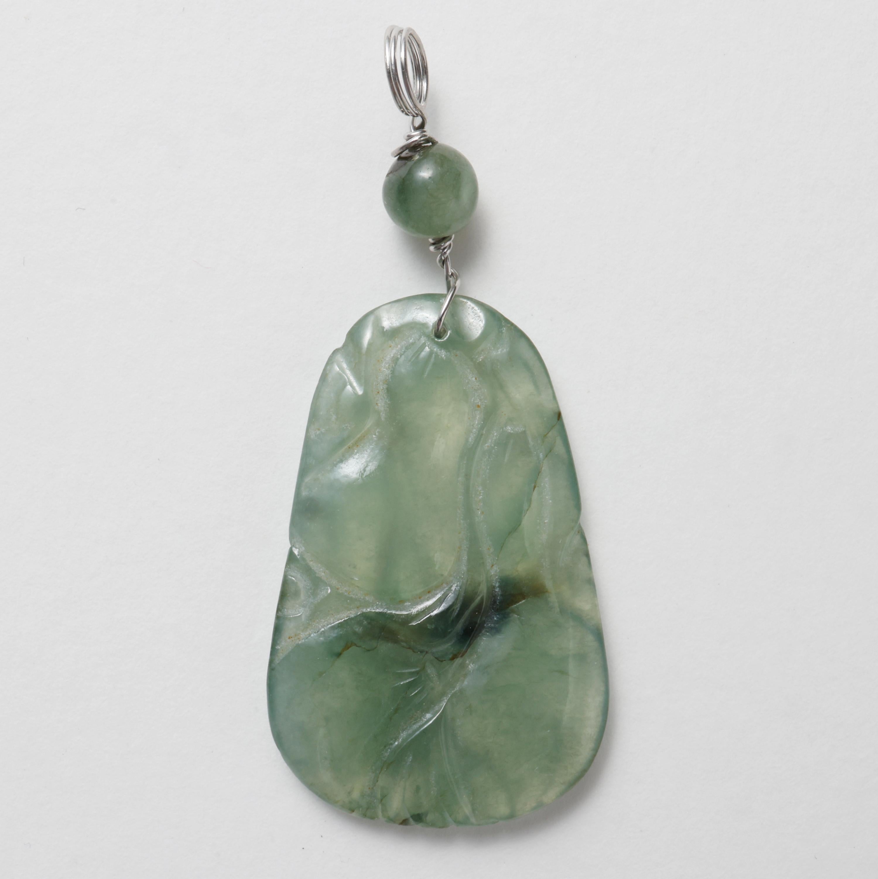 So translucent that it's nearly semi-transparent, this early Art Deco era (circa 1920) natural and untreated Burmese jadeite jade pendant has been carved to depict a grouping of melons or gourds. The lines of the carving are clean, sketch-like in