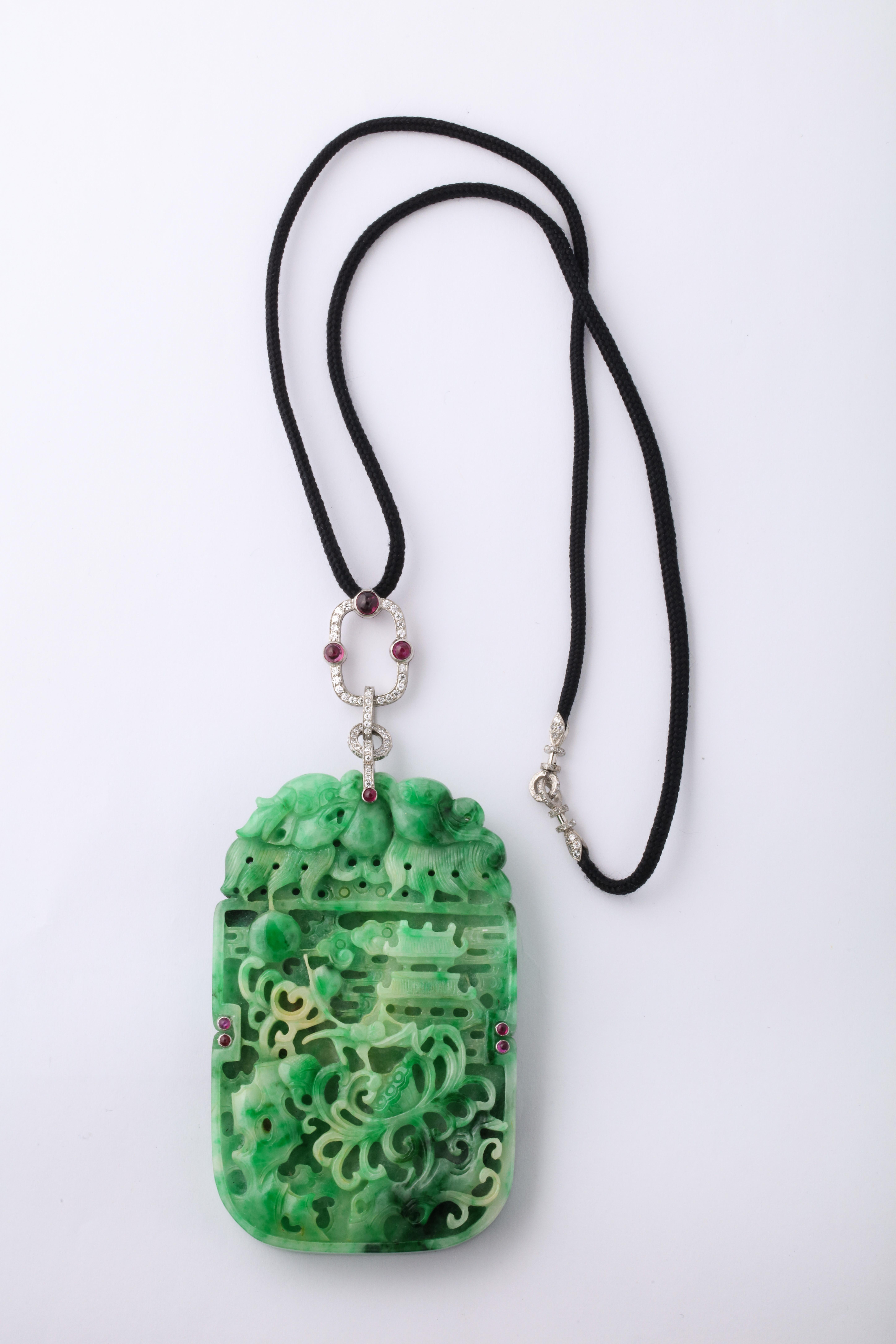 Very large and fine carved Art deco jade necklace set with diamonds and cabochon rubies on a silk tassel. 

Most likely made in France but unmarked. 