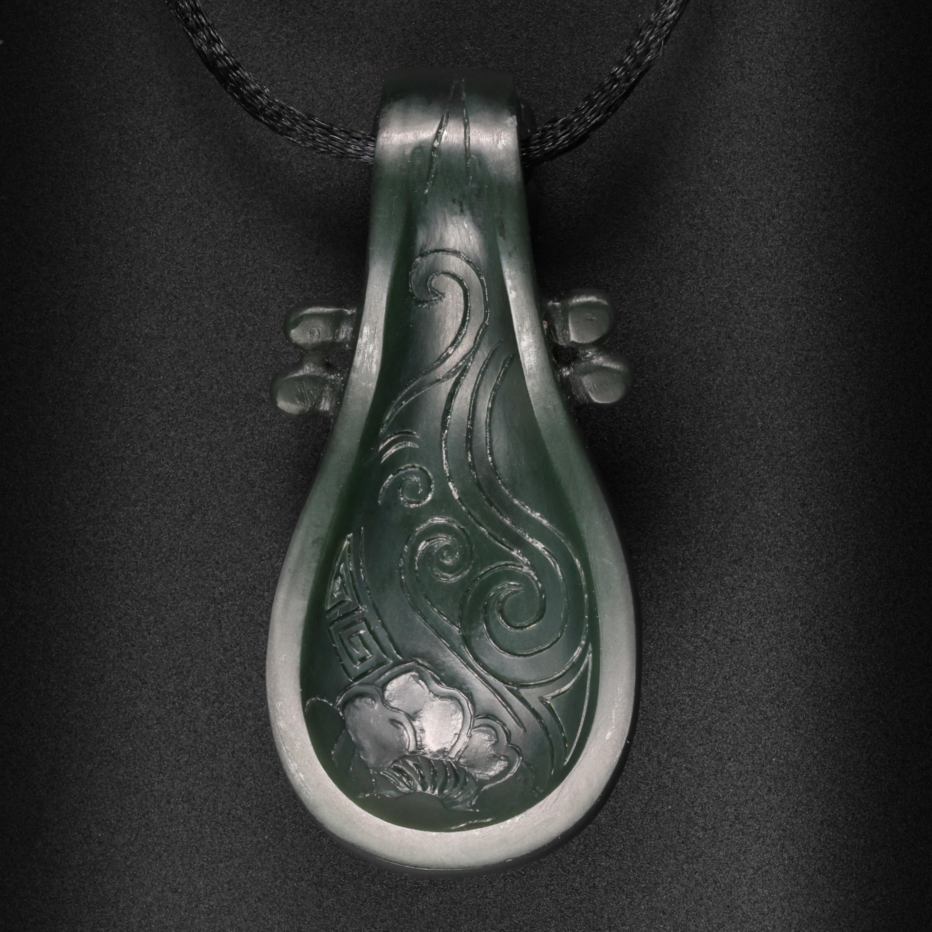 This wonderful and exceedingly rare contemporary, (new) pendant depicts a pipa, which is a Chinese stringed instrument similar to a lute. The pipa was carved from slightly bluish-green Junlun jade, which is sourced from the Kunlun mountains in