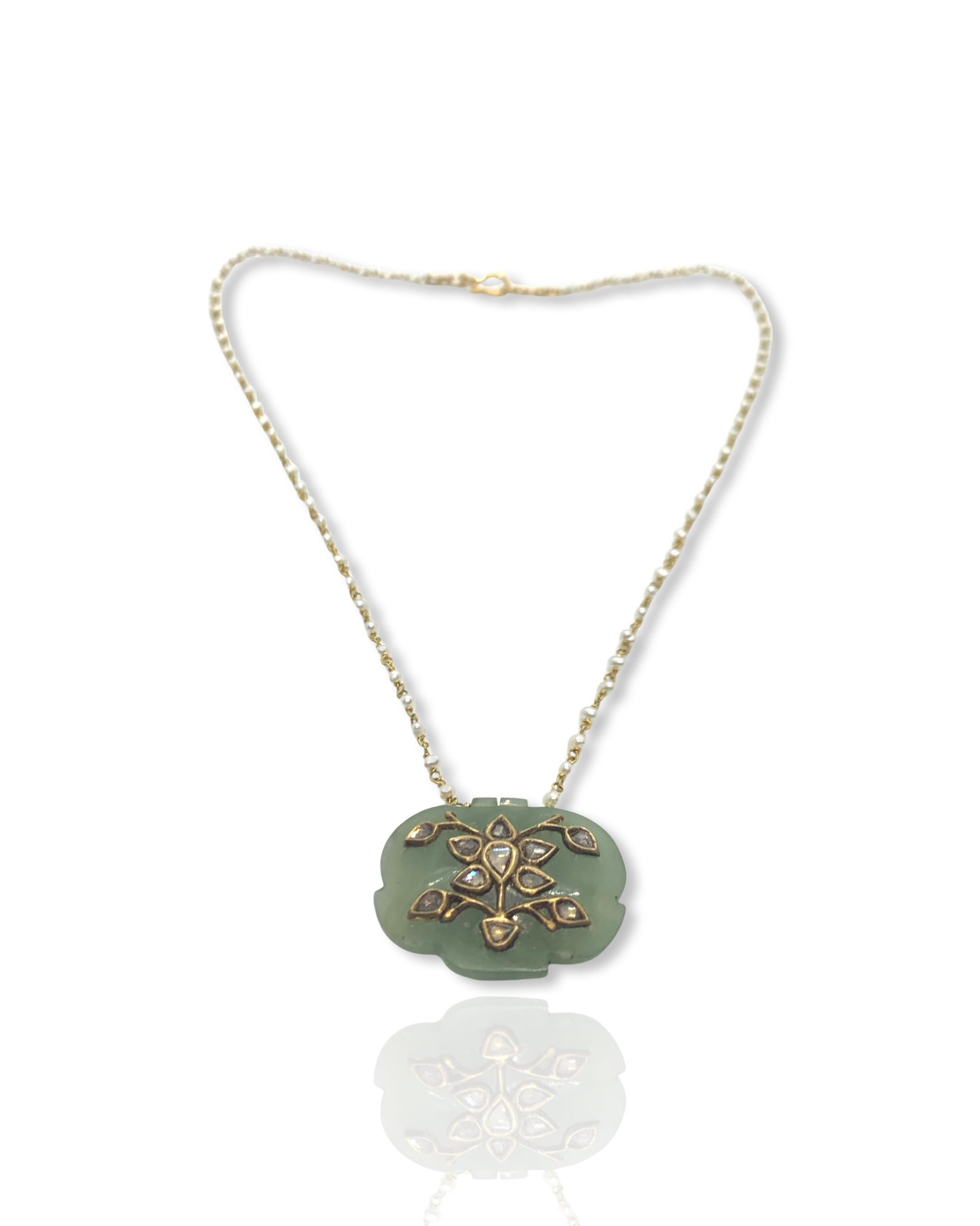 A beautiful jade pendant studded with diamonds strung in a chain of pearl beads.
The pearls are hand strung in 18K Gold and the necklace ends with a fish hook to make it easier for the wearer and secure at the same time. Such Jade pendants can be