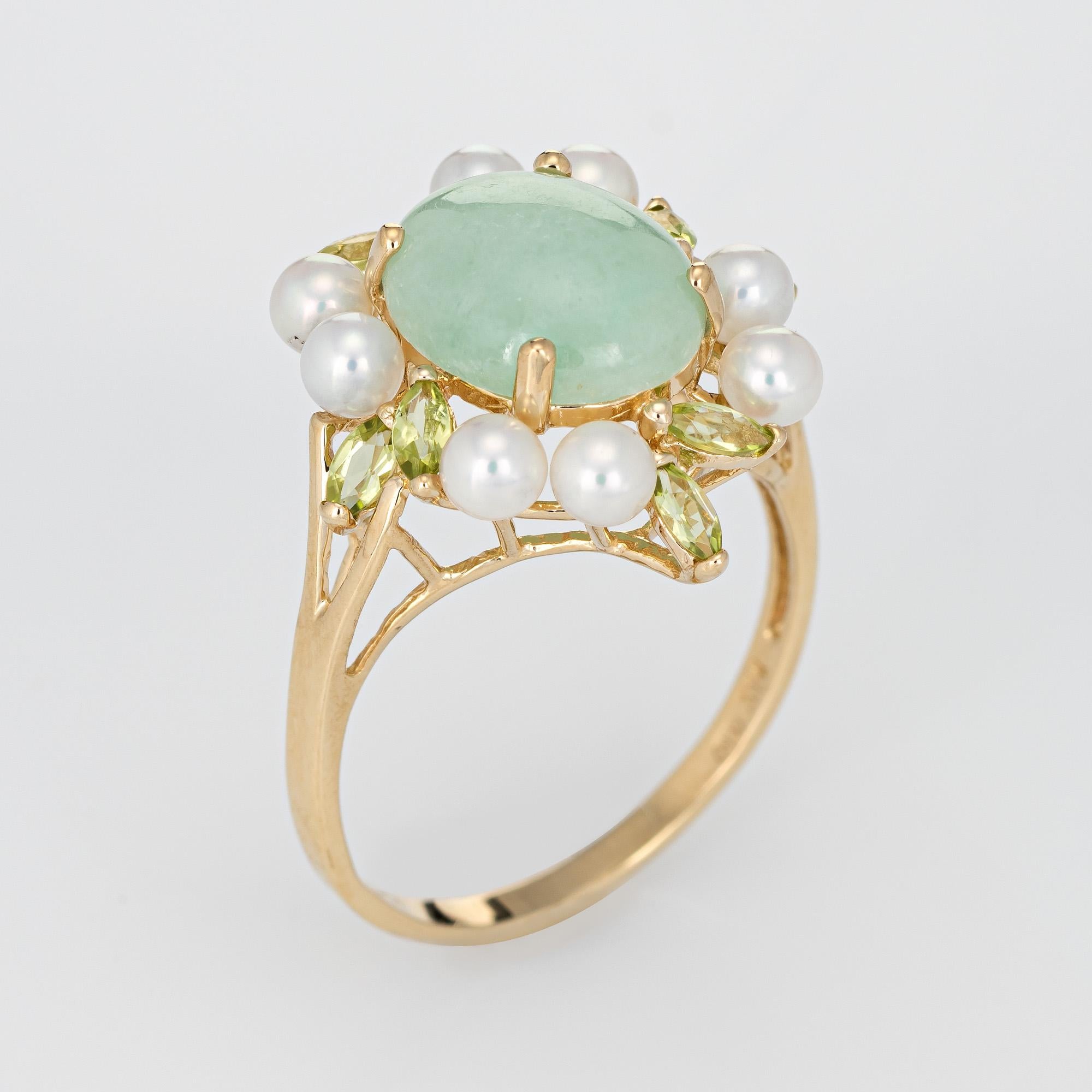 Stylish jade, peridot and cultured pearl cocktail ring crafted in 14 karat yellow gold. 

Cabochon cut jade measures 12mm x 10mm (estimated at 7 carats), accented with an estimated 0.80 carats of peridot. The cultured pearls measures 4mm each. The