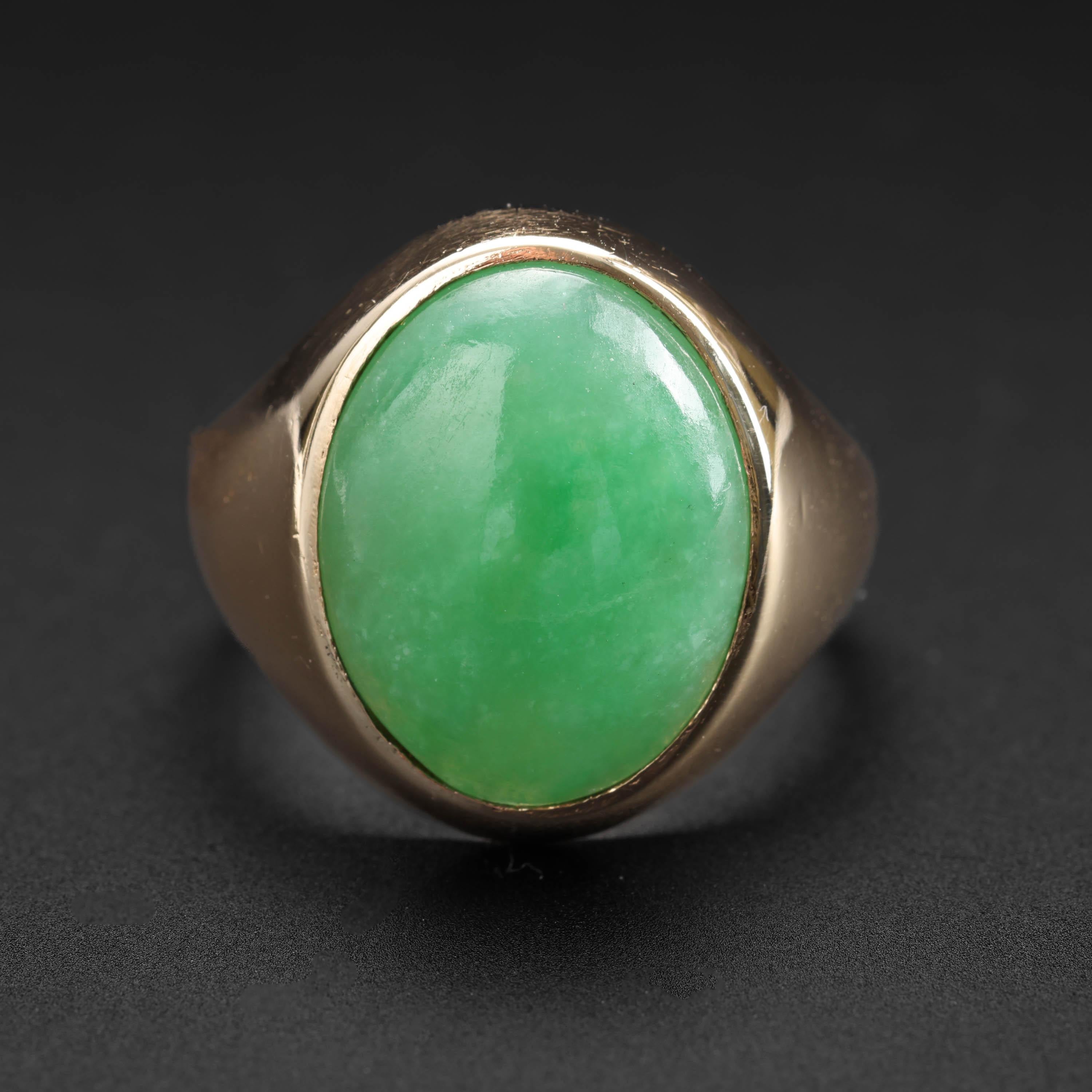 This classic midcentury jade ring features a cabochon of lush, translucent apple green natural and untreated jadeite jade from Burma.  

The sleek 14k yellow gold band is exceedingly comfortable. The 15.18 x 12.4 x 3.91 jade cabochon has an even