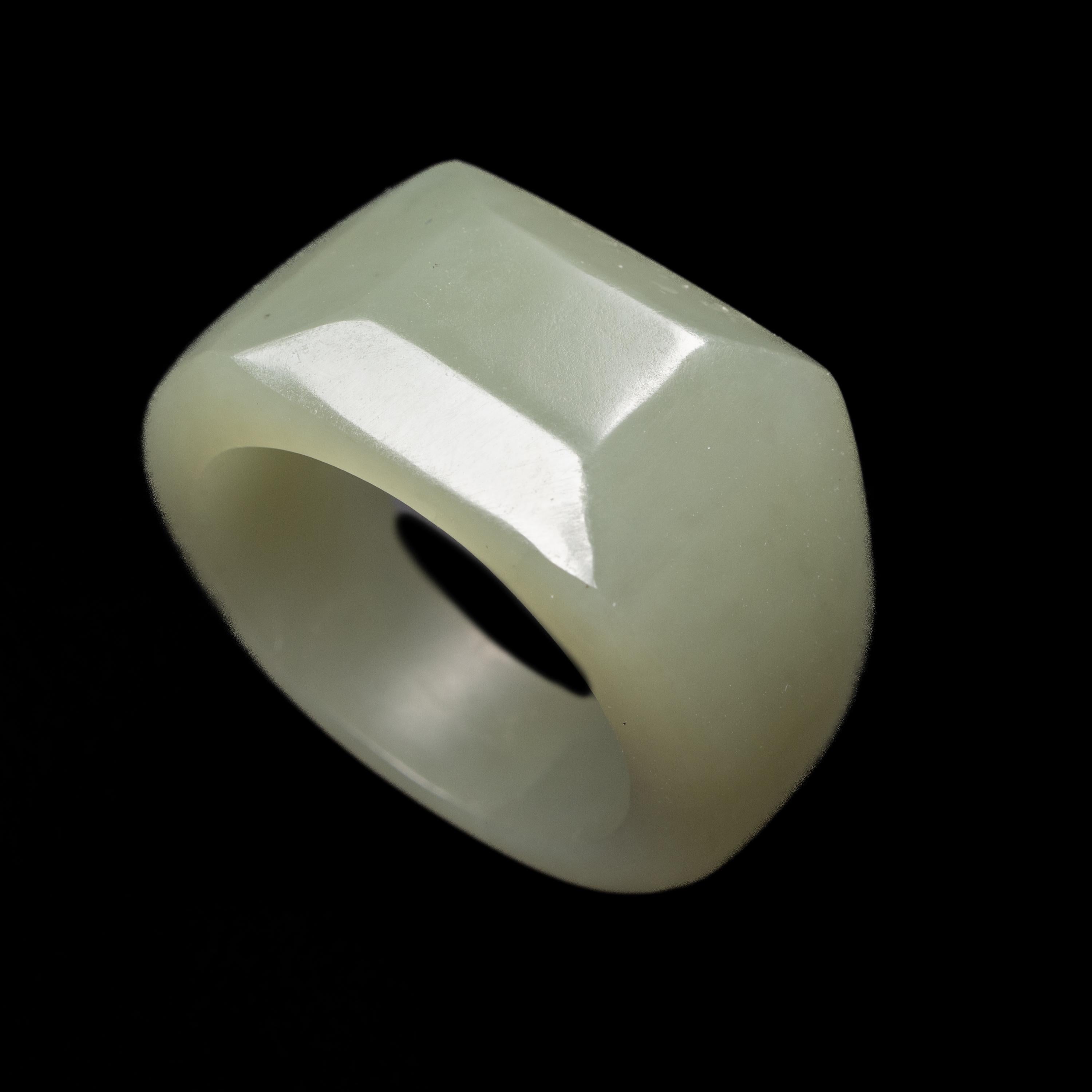 Masterfully carved by a lapidary artist in China -nationally recognized- from light grayish-green fine Chinese nephrite, this is no ordinary carved jade ring. It features a flat surface atop chamfered edges, giving it a distinctly modern
