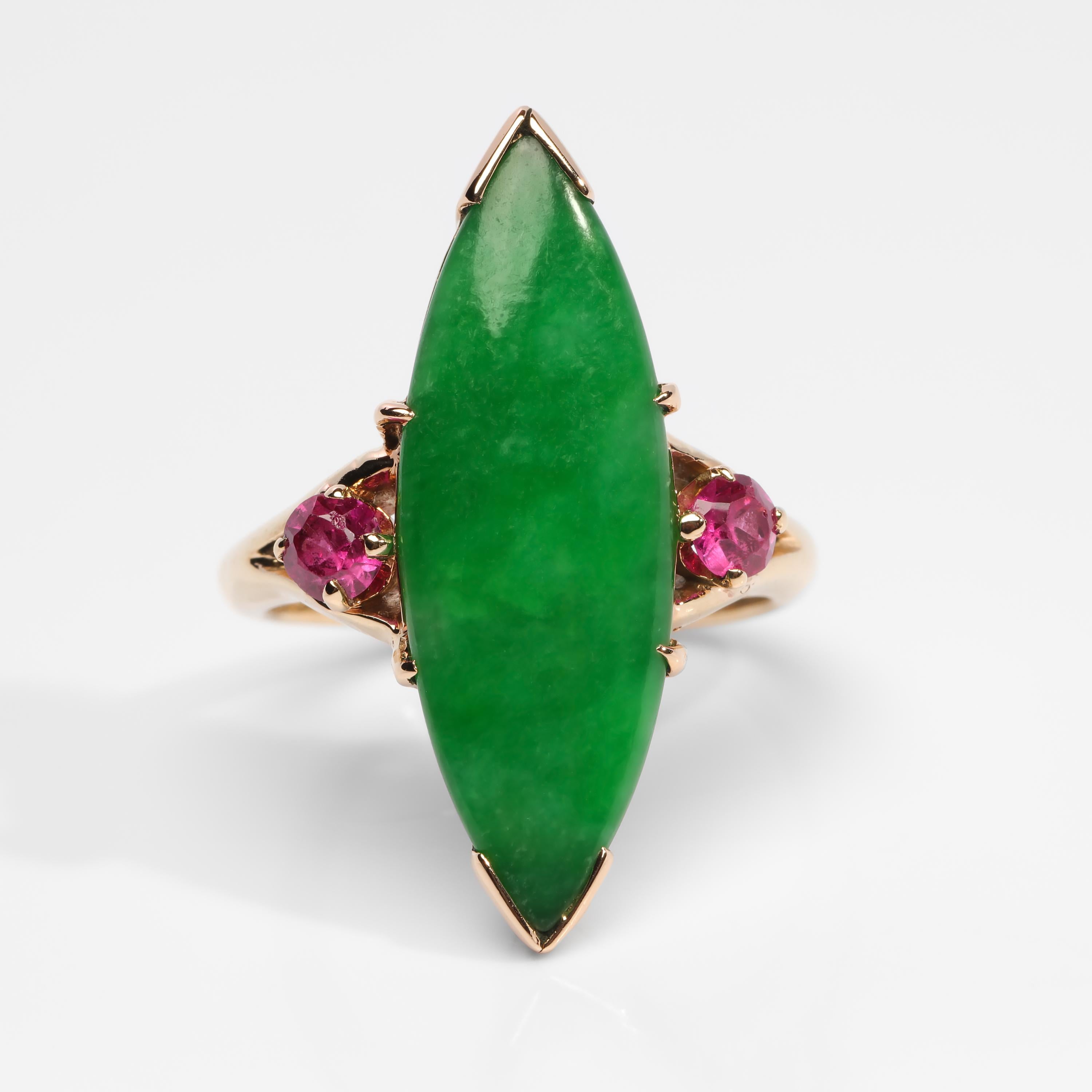 This spectacular ring from the 1940s features an exceptionally fine vivid apple-green jadeite jade cabochon certified by the GIA to be natural and untreated jadeite from Burma. Poised on either side of this glorious and rare gem is a pair of small,