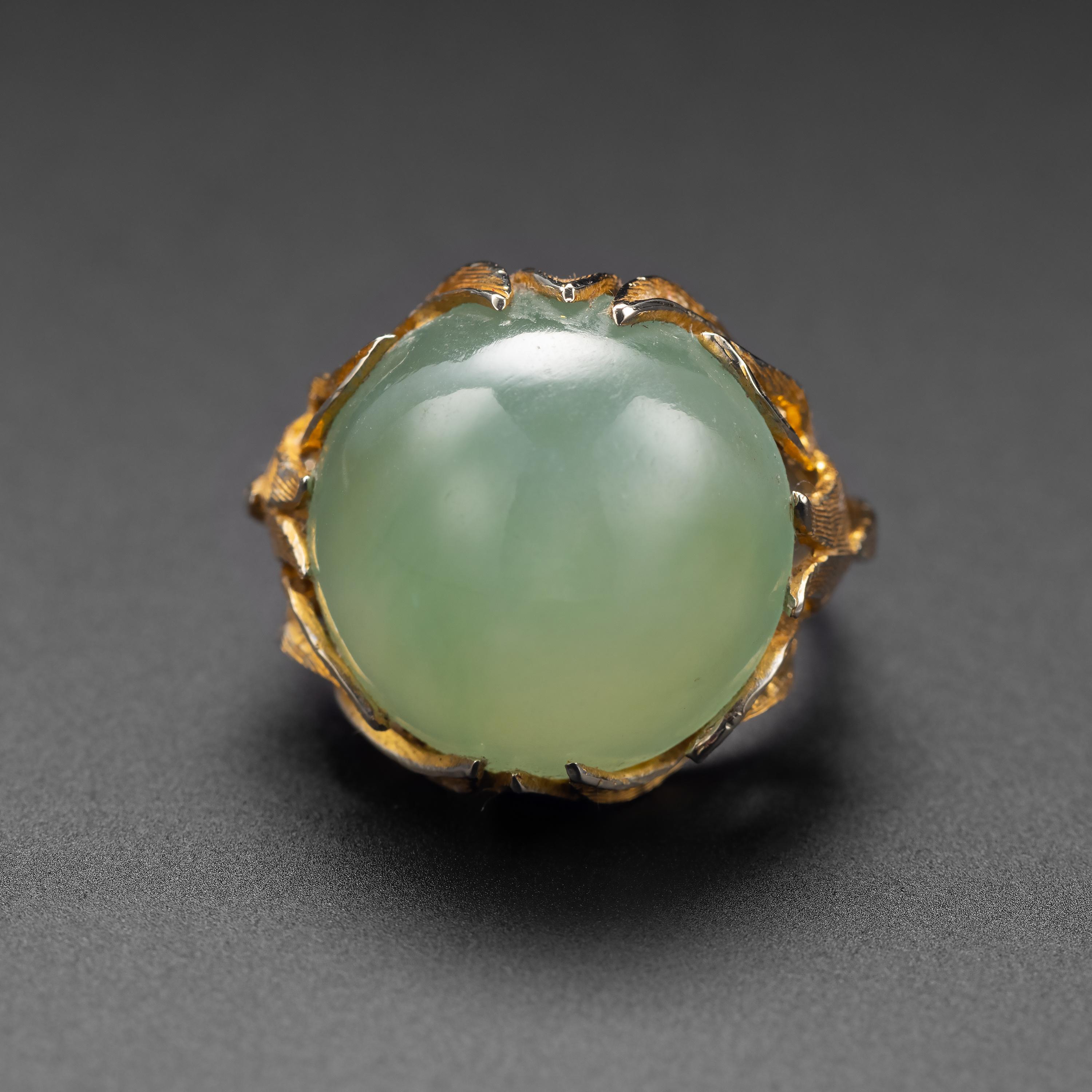 A spectacular and huge —18.3mm— cabochon of luminous, ethereal, light sage-green Burmese jadeite jade is the focal point of this midcentury treasure. The gilt silver mounting was hand-fabricated and deeply carved to resemble leaves. The workmanship