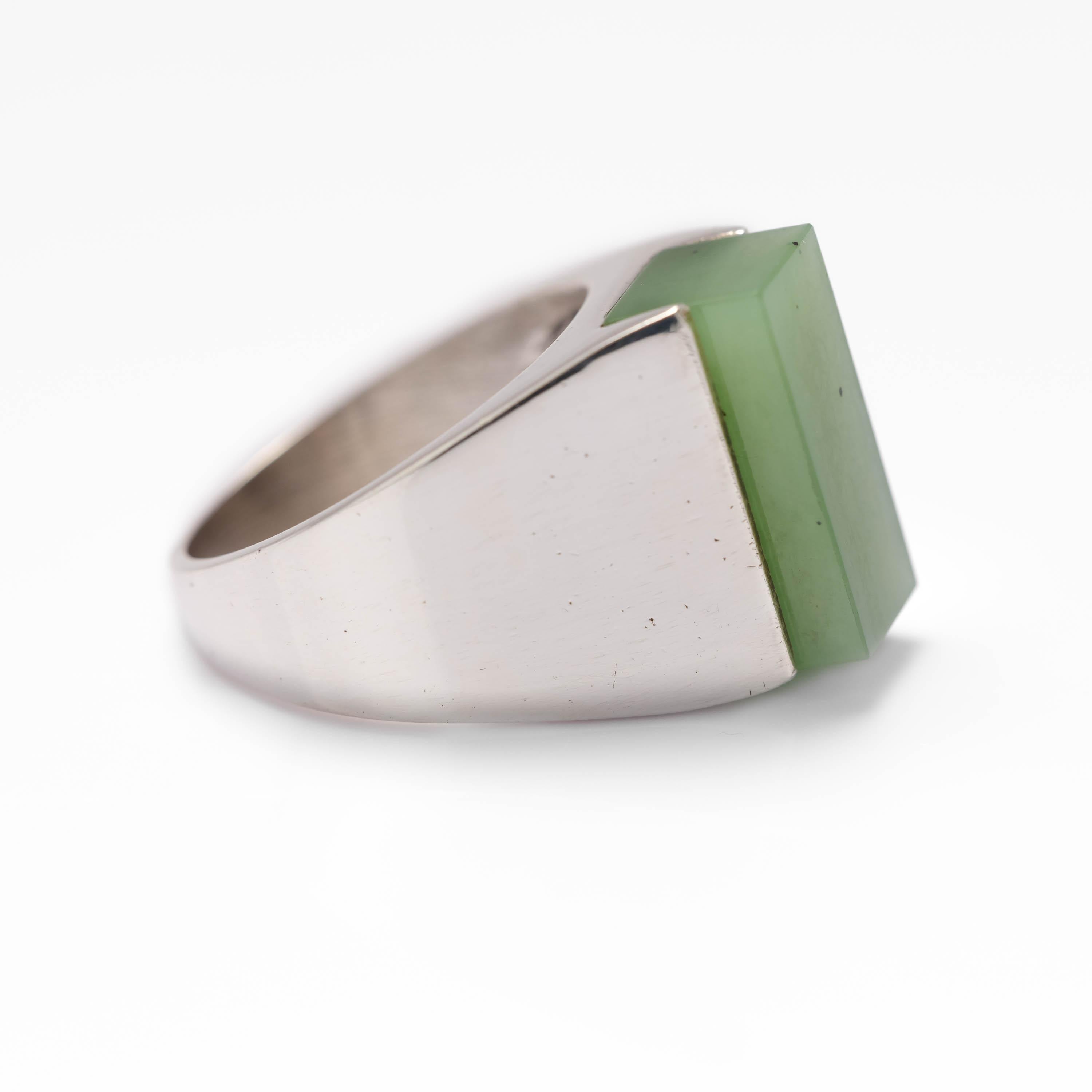 Bold and architectural, this modernist sterling silver and certified natural and untreated nephrite jade ring was created in the 1960s or early 1970s, most likely in Denmark.

The gleaming silver mounting is a work of art in itself. But the focal