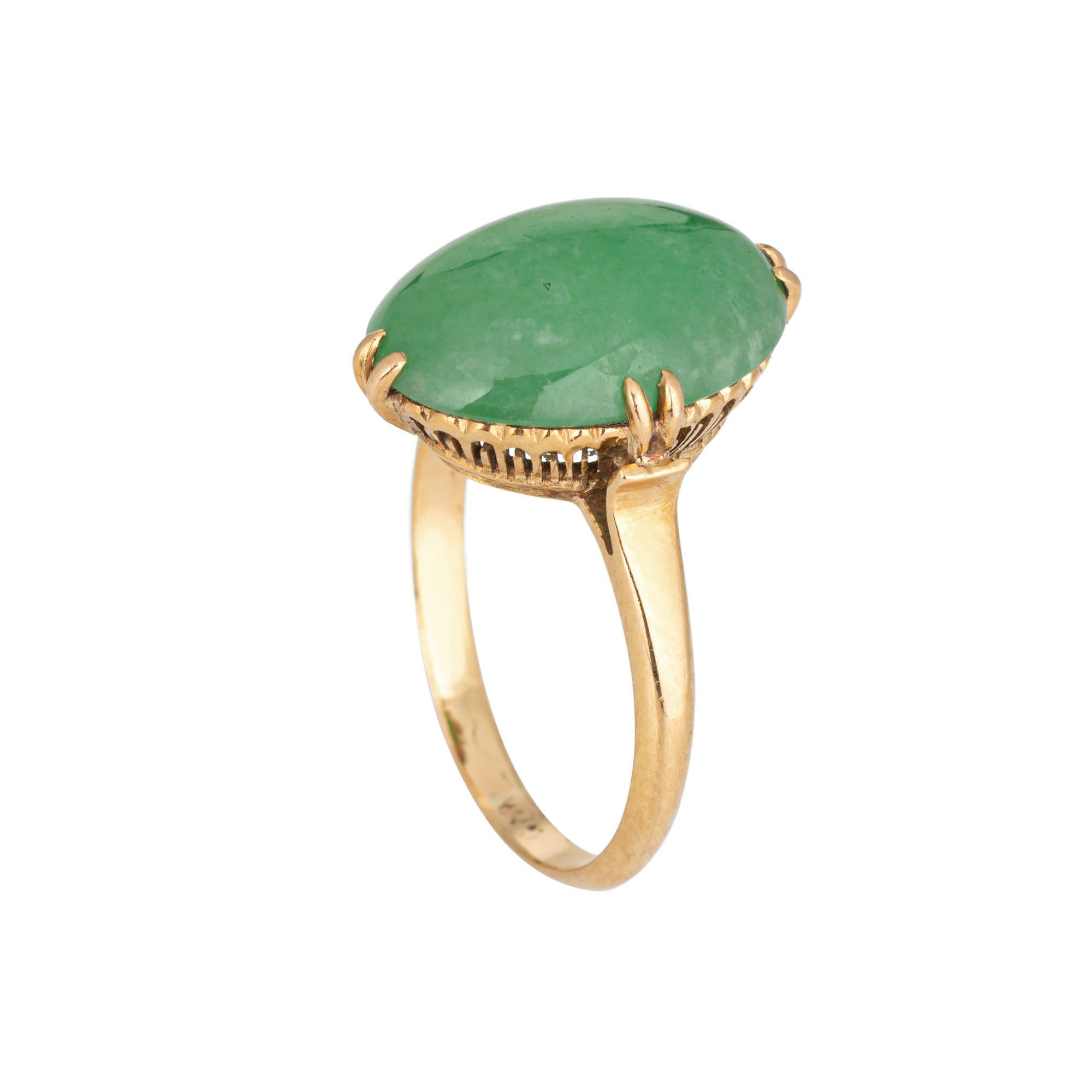 Stylish vintage jade ring (circa 1950s to 1960s) crafted in 14 karat yellow gold. 

Jade measures 14mm x 9.5mm. The jade is in good condition and free of cracks or chips. 

The oval mount highlights beautiful green jade. Measuring just over 1/2 inch