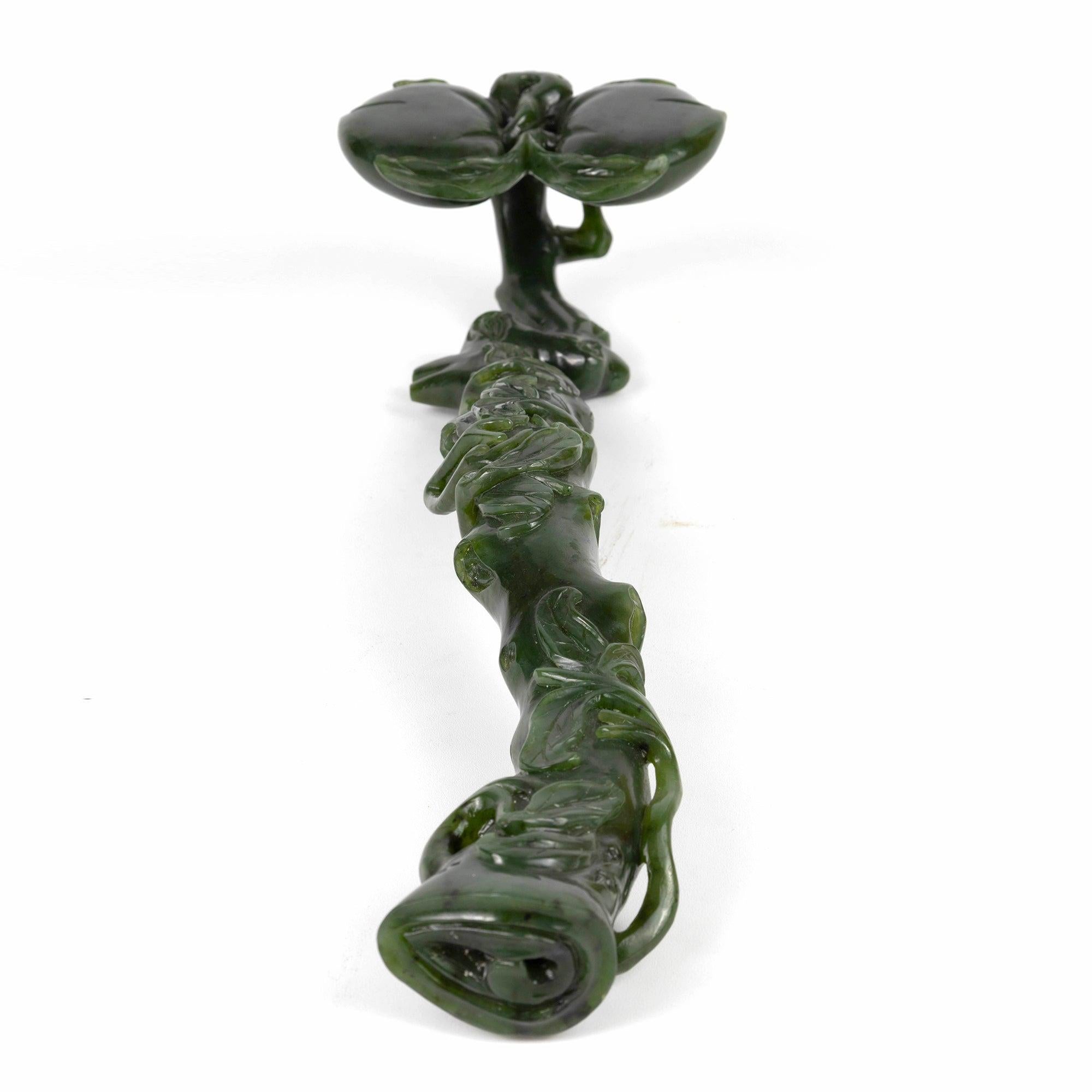JADE RUYI 
La superficie superior del asa está tallada en altorrelieve para representar dos melocotones en flor y hojas alrededor.
Chino 
siglo XX
Longitud: 30 cm (12 pulg.)
