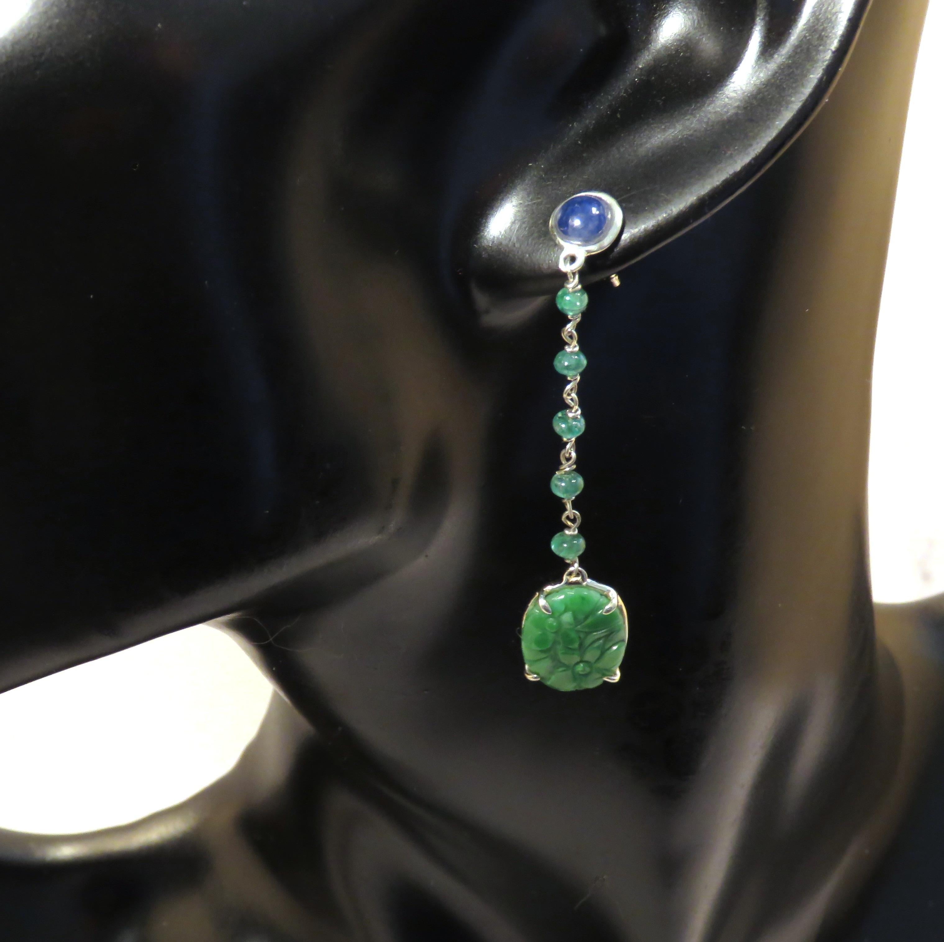 Beautiful dangle earrings featuring a lovely mix of natural green jade, sapphires and emeralds. Each earring is handcrafted in 9 karat white gold with 2 green carved jades, 2 cabochon cut sapphires and emerald beads. The green jade is all natural,