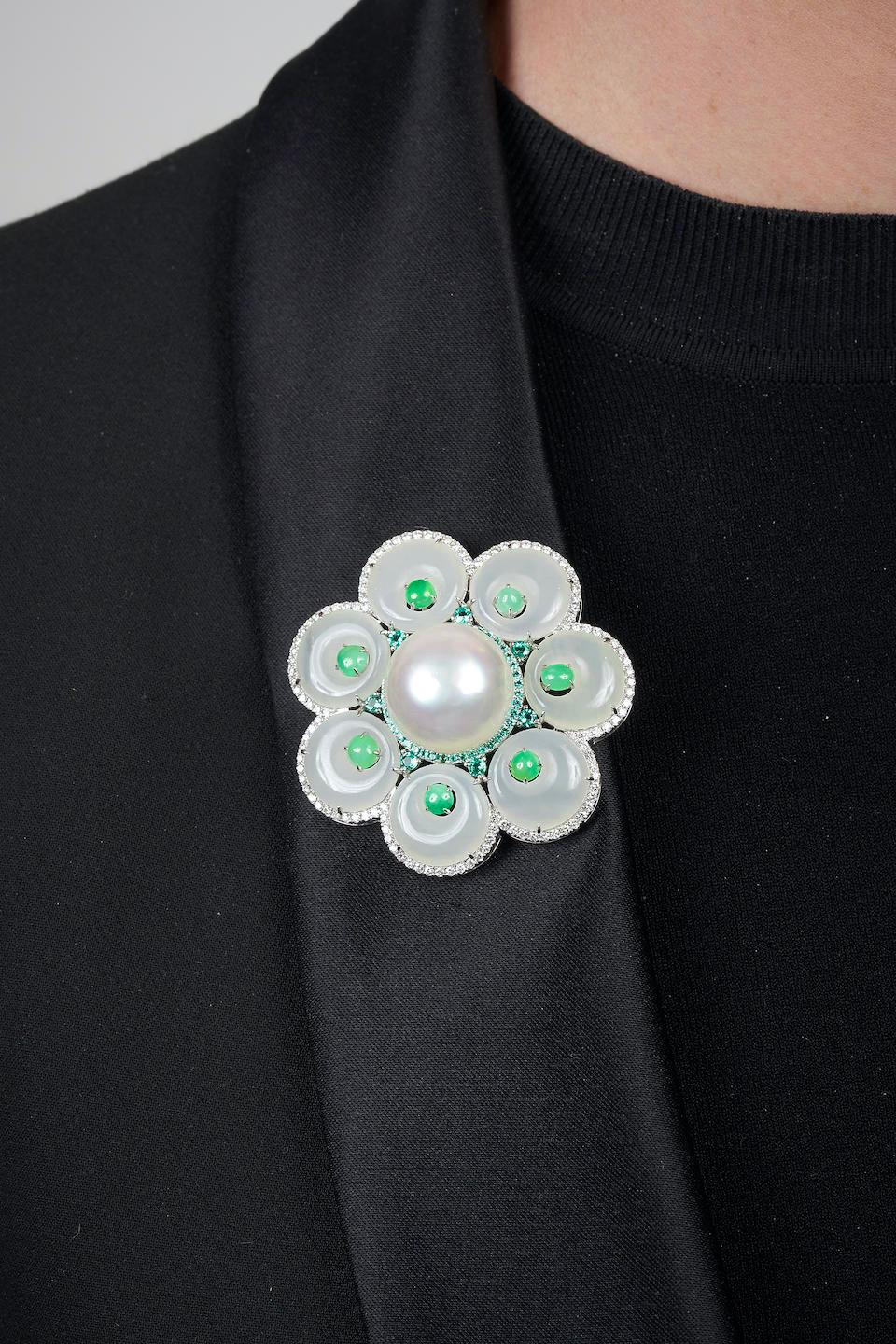 Designed as a flower, centrally set with a South Sea pearl, measuring approximately 17.90mm, within a border of tsavorite garnets, the nephrite petals enhanced with jadeite cabochons and framed by a border of round brilliant-cut diamonds, fitted
