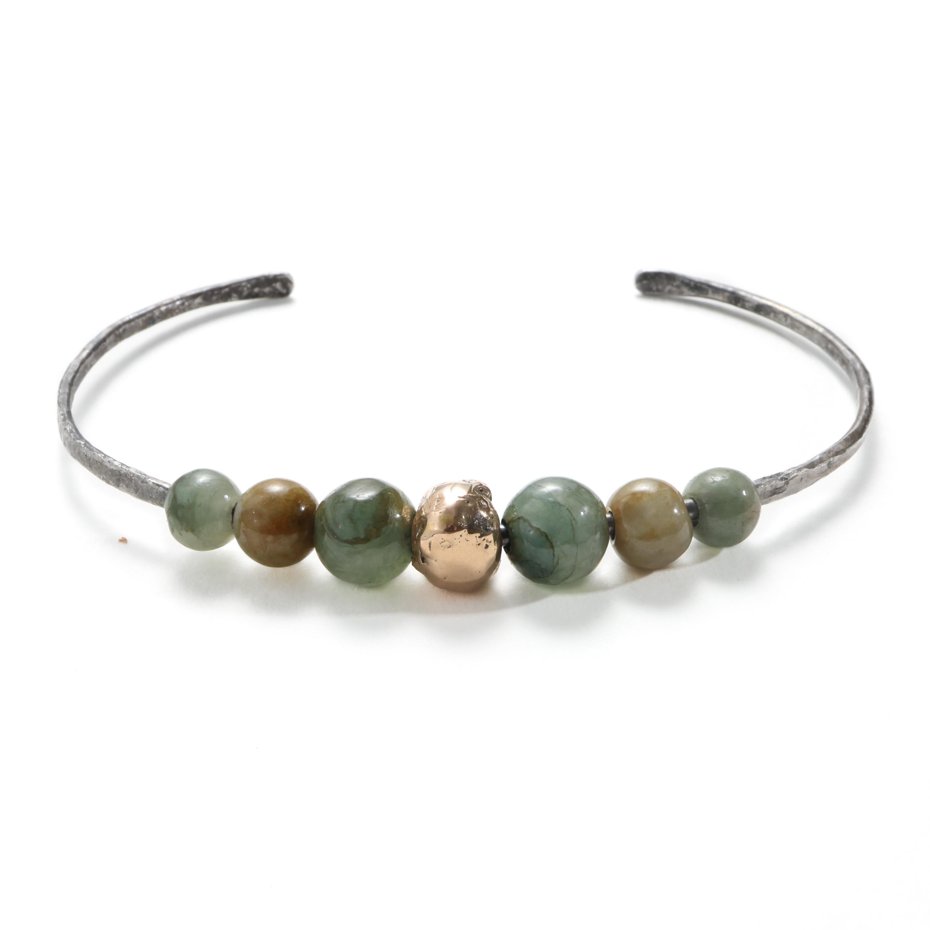 Fire-blackened steel, hand worked to achieve a hammered finish, then formed into the form of a 