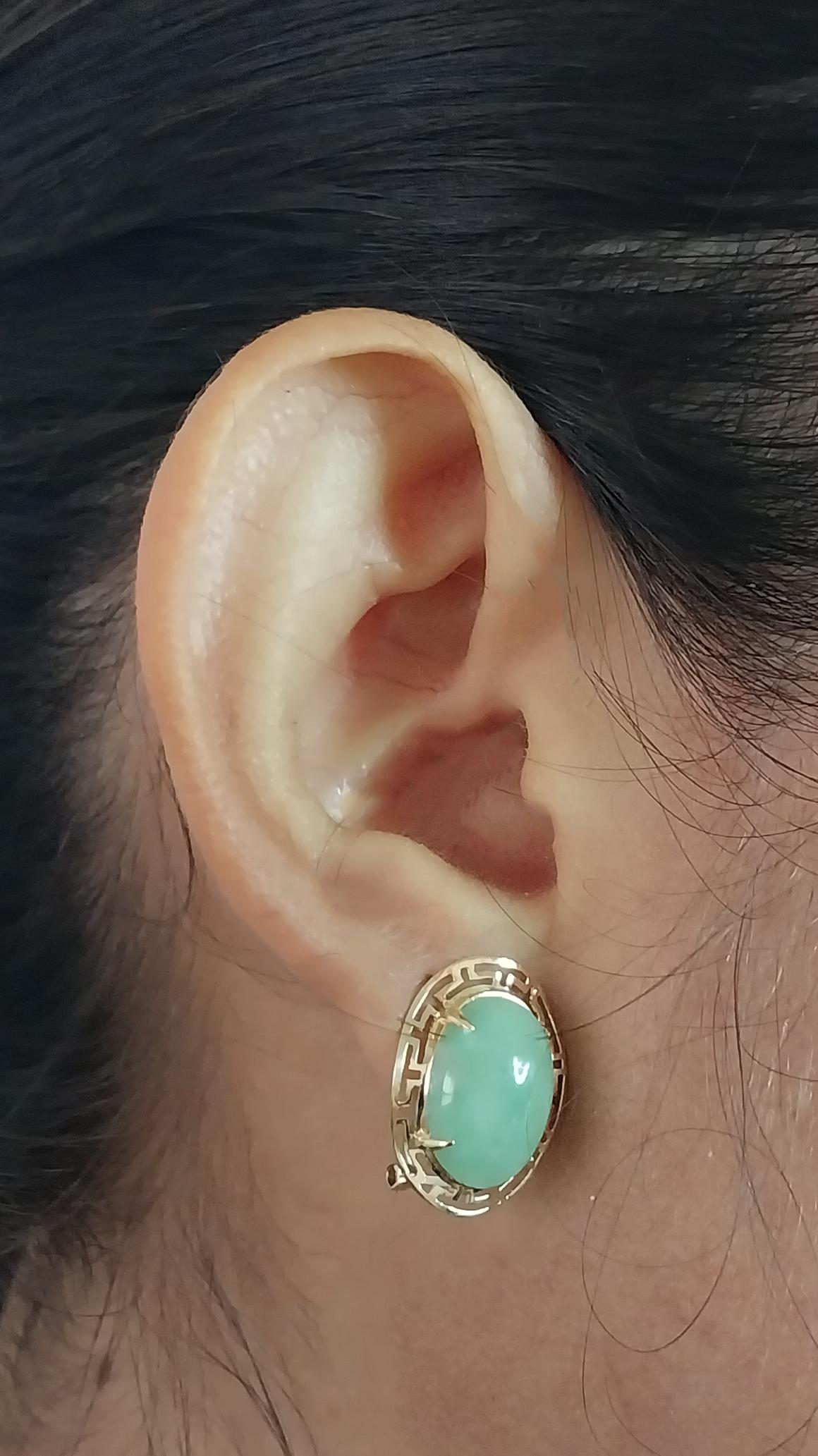 14 Karat Yellow Gold Earrings Featuring Two 14mm x 10mm Oval Cabochon Jade Surrounded with a Gold Border. 0.75 Inches Long. Pierced Post with Omega Clip Back. Finished Weight is 4.2 Grams.