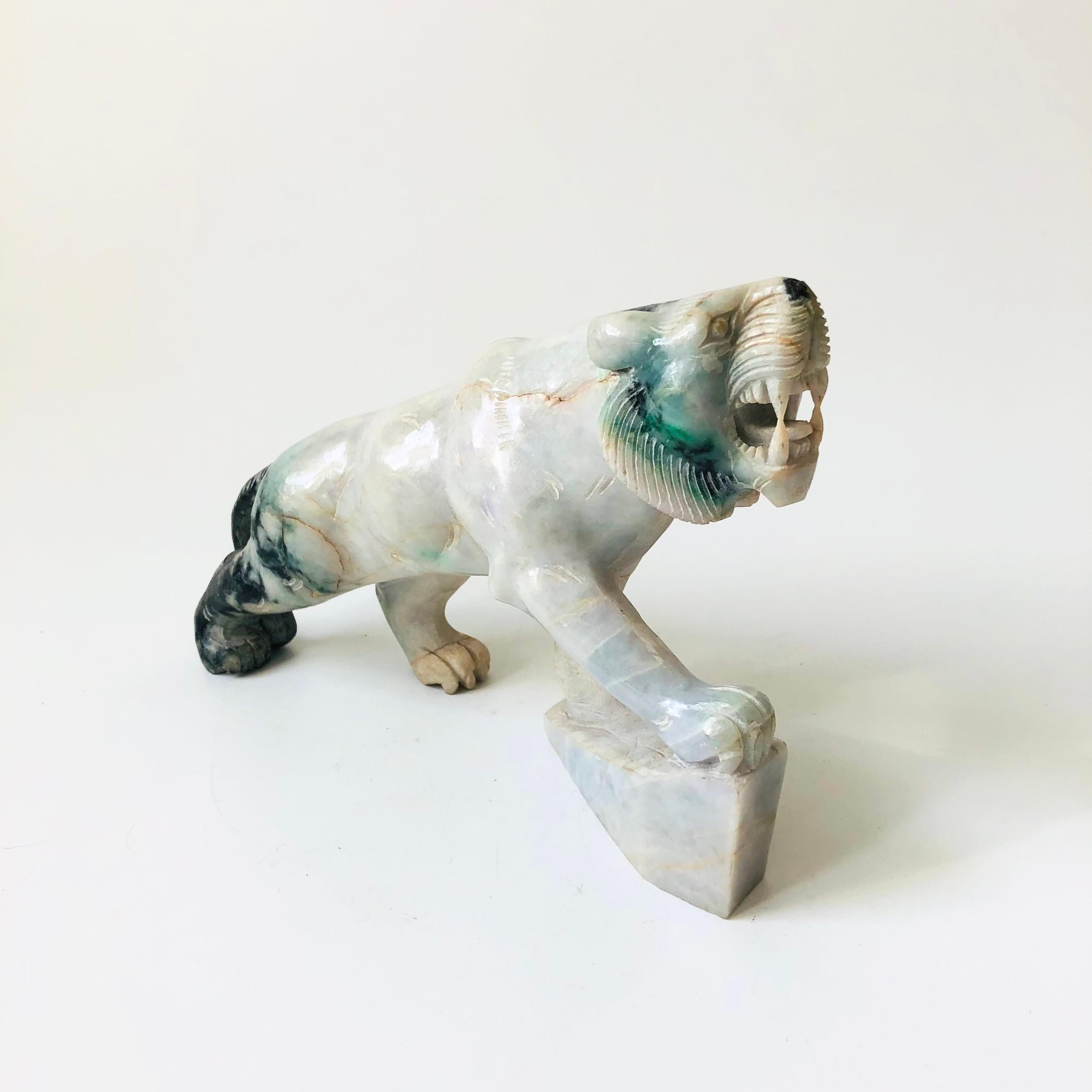 A vintage carved jade tiger. Beautiful veining and coloring to the stone that ranges from dark to pale greens. Lots of detailing carved into the stone. Good medium side to use as a statement piece.

