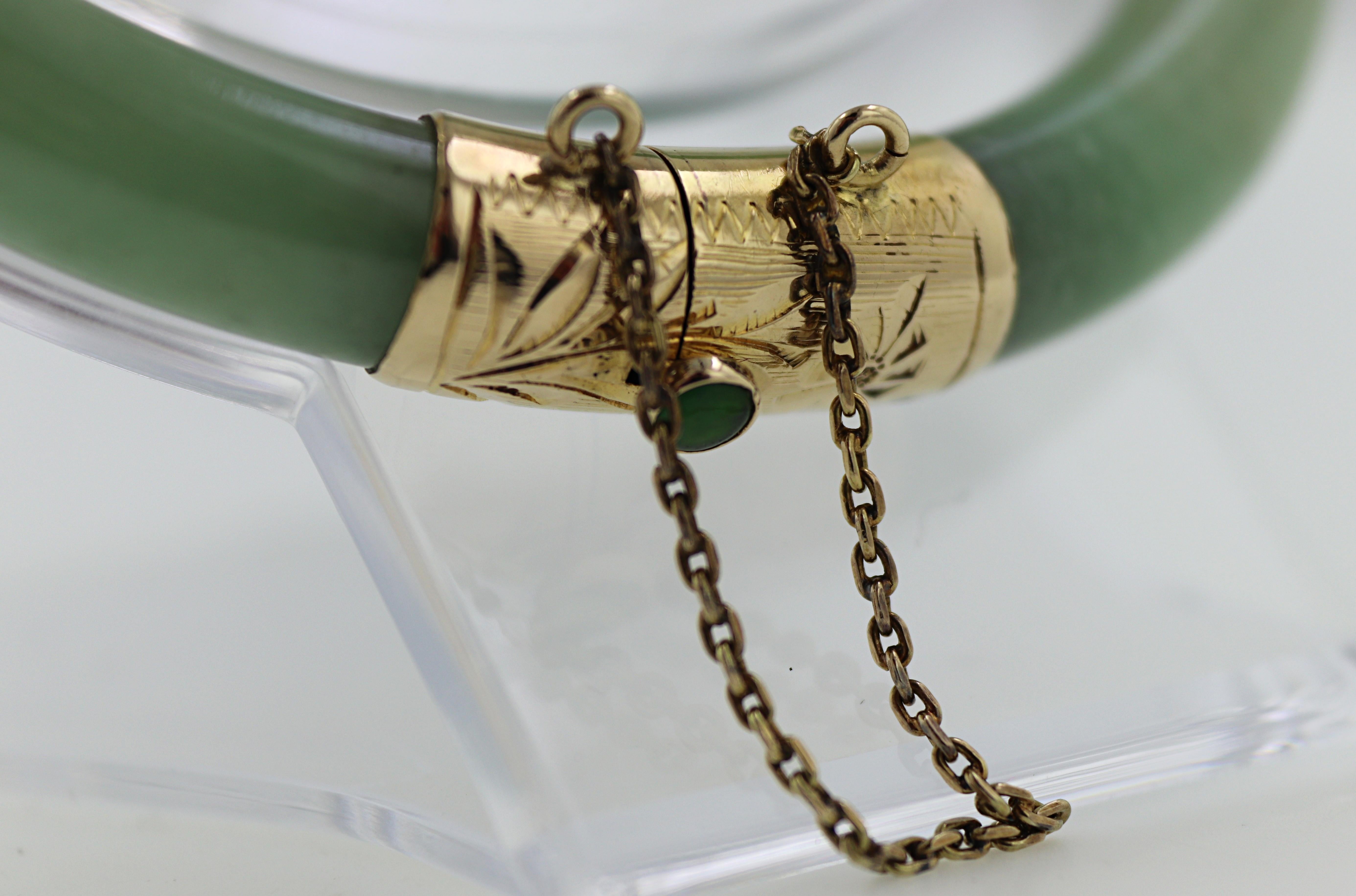 Ausgestattet mit (2) Jadeit-Segmenten, 73,9 x 7,6 mm, vervollständigt durch ein mit Blättern graviertes Scharnier aus 14k Gelbgold und
Verschluss, mit Jadeit-Cabochon, Druckknopf und Sicherheitskette, Innendurchmesser 57,3 mm,
markiert 14K, 585,