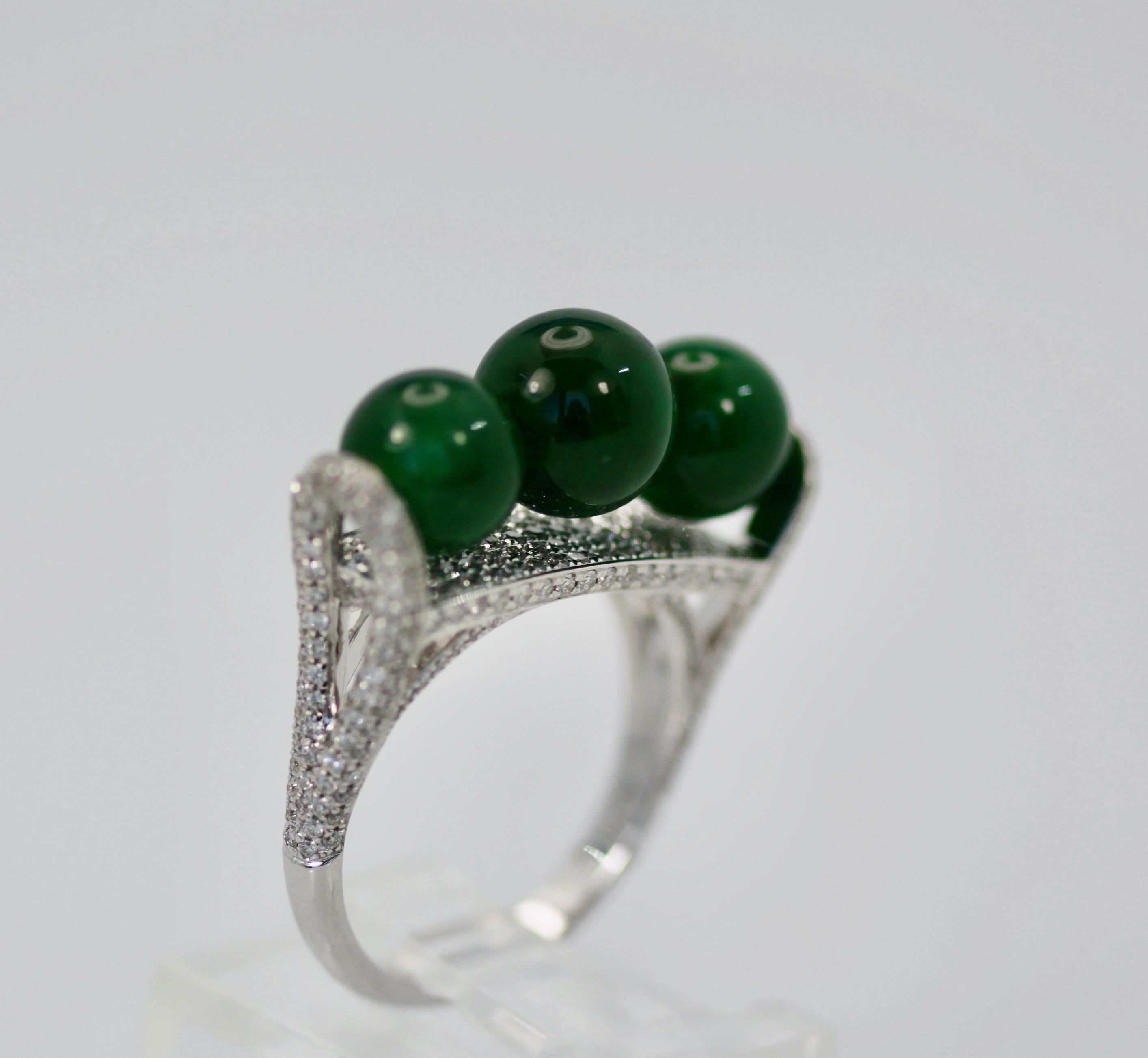 This gorgeous ring comes out of a Sotheby's Fine Jadeite and Jade auction in Hong Kong.  It consists of three (3) Jadeite Beads 7.75 round on a Diamond surround and base.  This ring is Jadeite, not Jade or Nephrite bit real Jadeite. These Beads glow