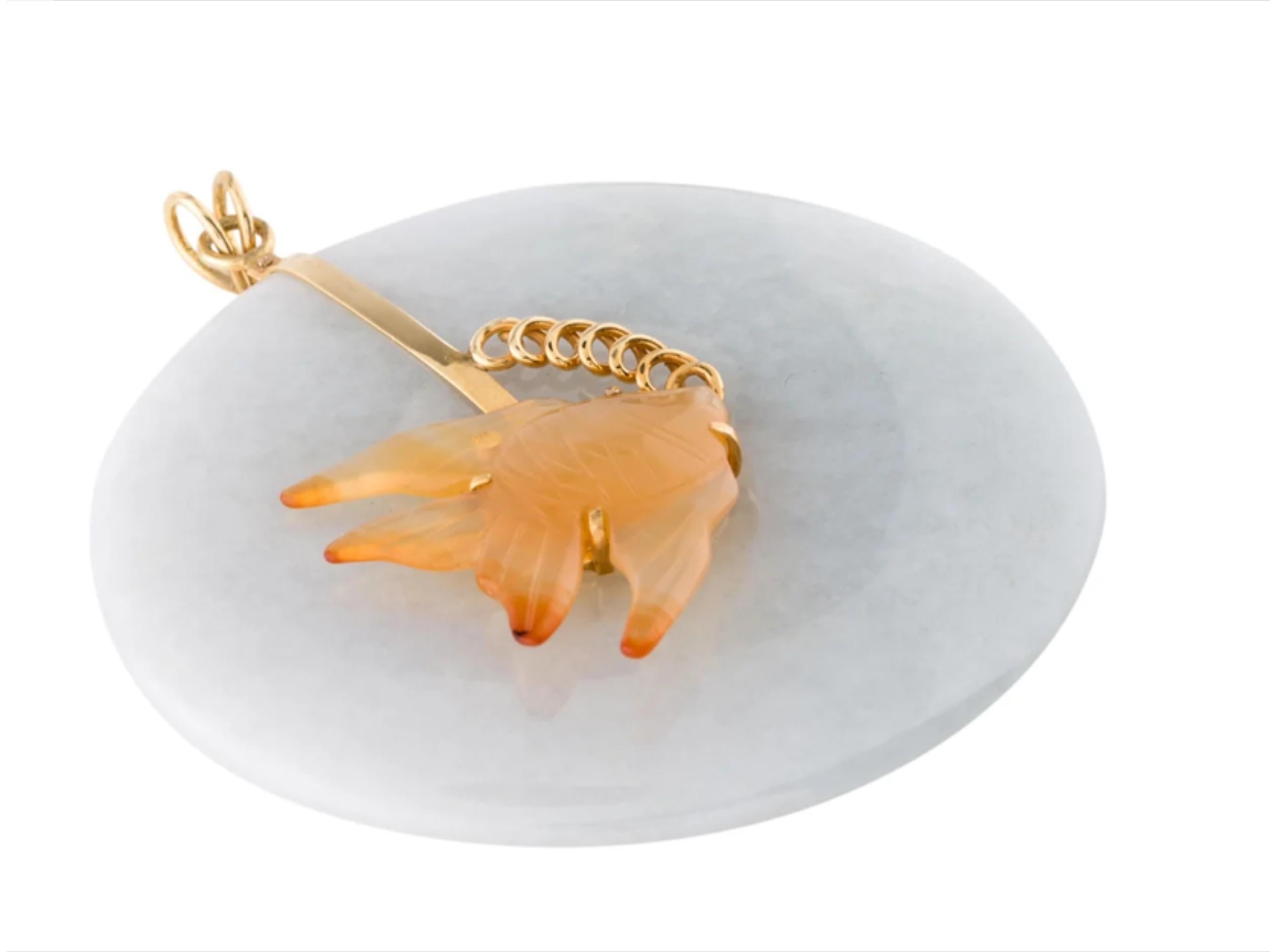 This lovely vintage749 pendant features a whimsical undersea tableau of a swimming angelfish. The angelfish is composed of carved orange agate with natural color gradations that give the fish interesting striping. The fish is prong-set in 14k yellow
