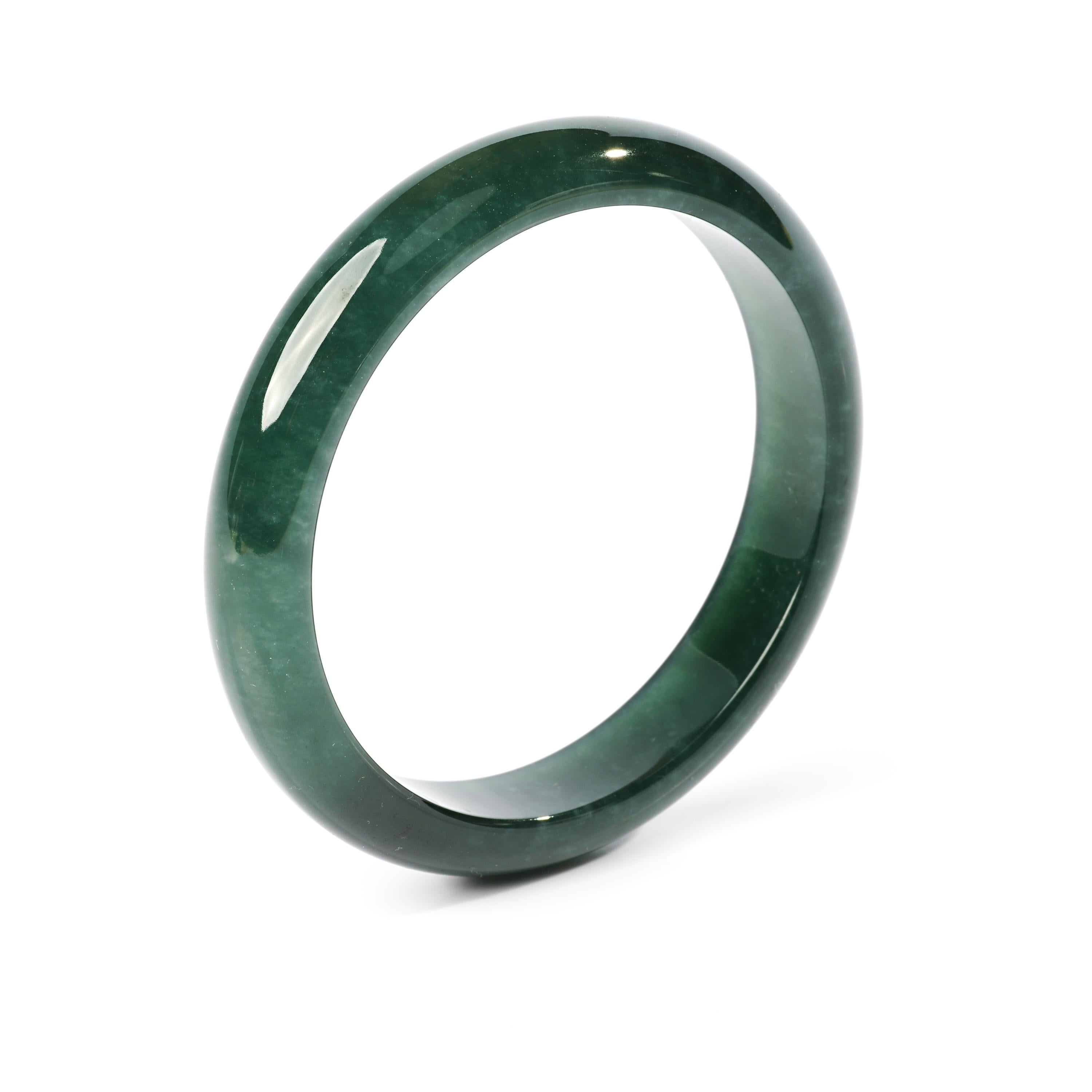 This bluish-green jadeite jade bangle is so translucent it looks like glass. It's the color of the ocean off the coast of Big Sur, California. If it fit me I would never take it off. 

Carved to perfection, this gorgeous and rare bangle has an inner
