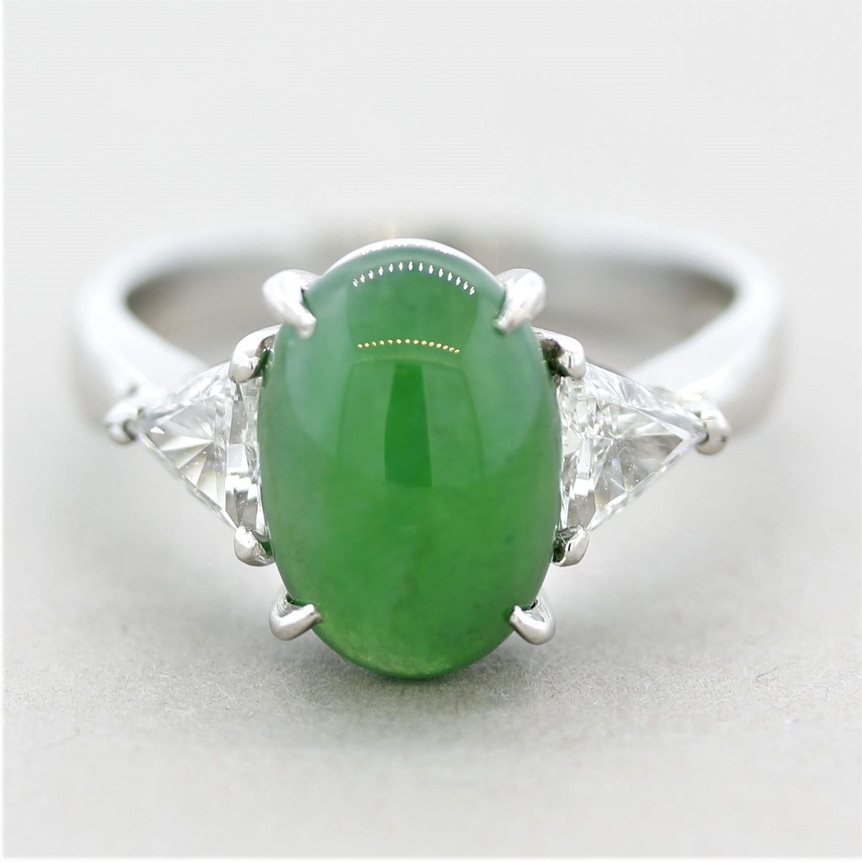 A classic 3-stone ring featuring a 3.65 carat natural jadeite jade! It has bright green color with excellent luster and translucency. It is accented by two triangular-shaped diamonds set on its sides and weigh a total of 0.52 carats. Hand-fabricated